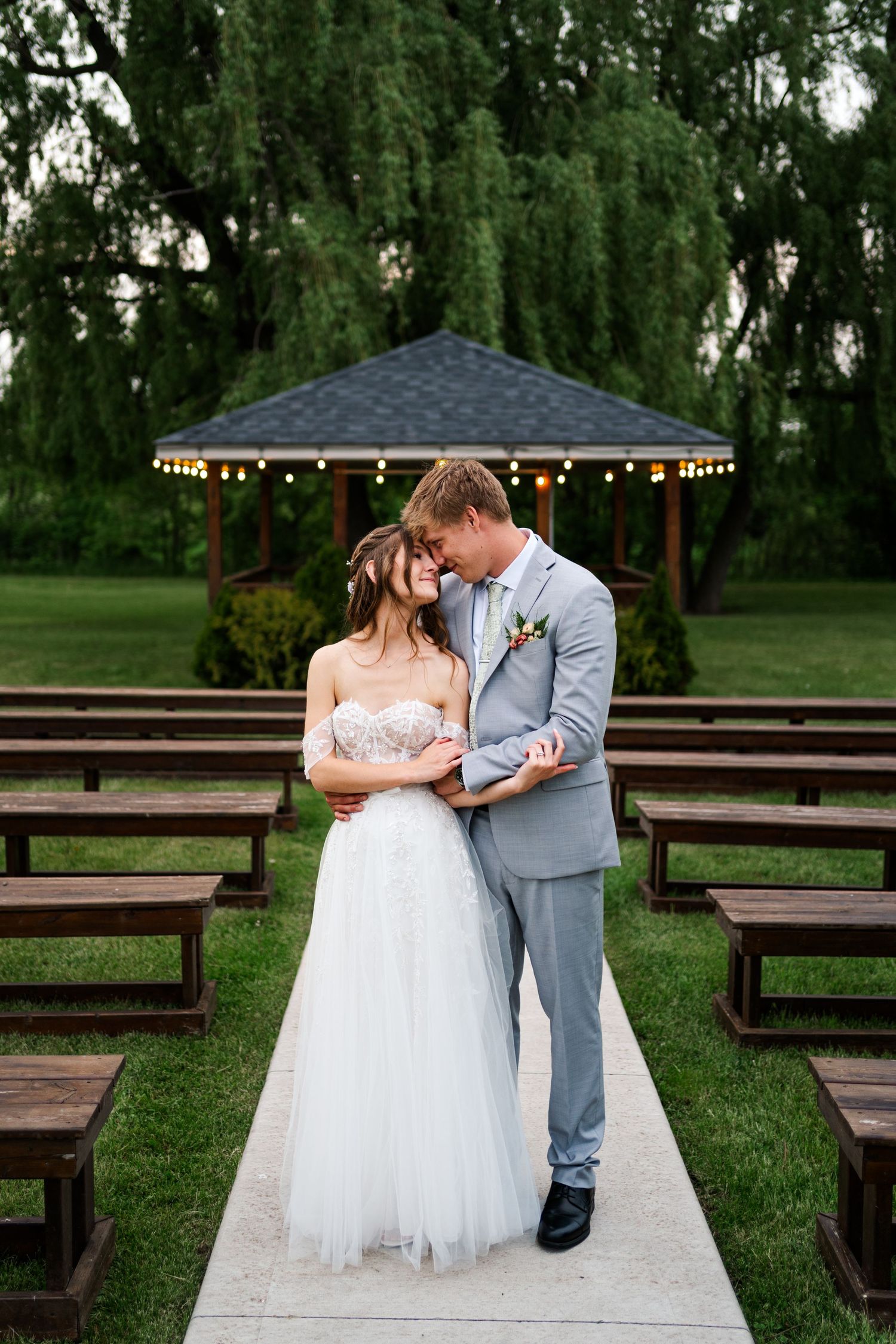 Newlyweds sharing intimate moment on wooden platform surrounded by trees.
Niagara Wedding photography.