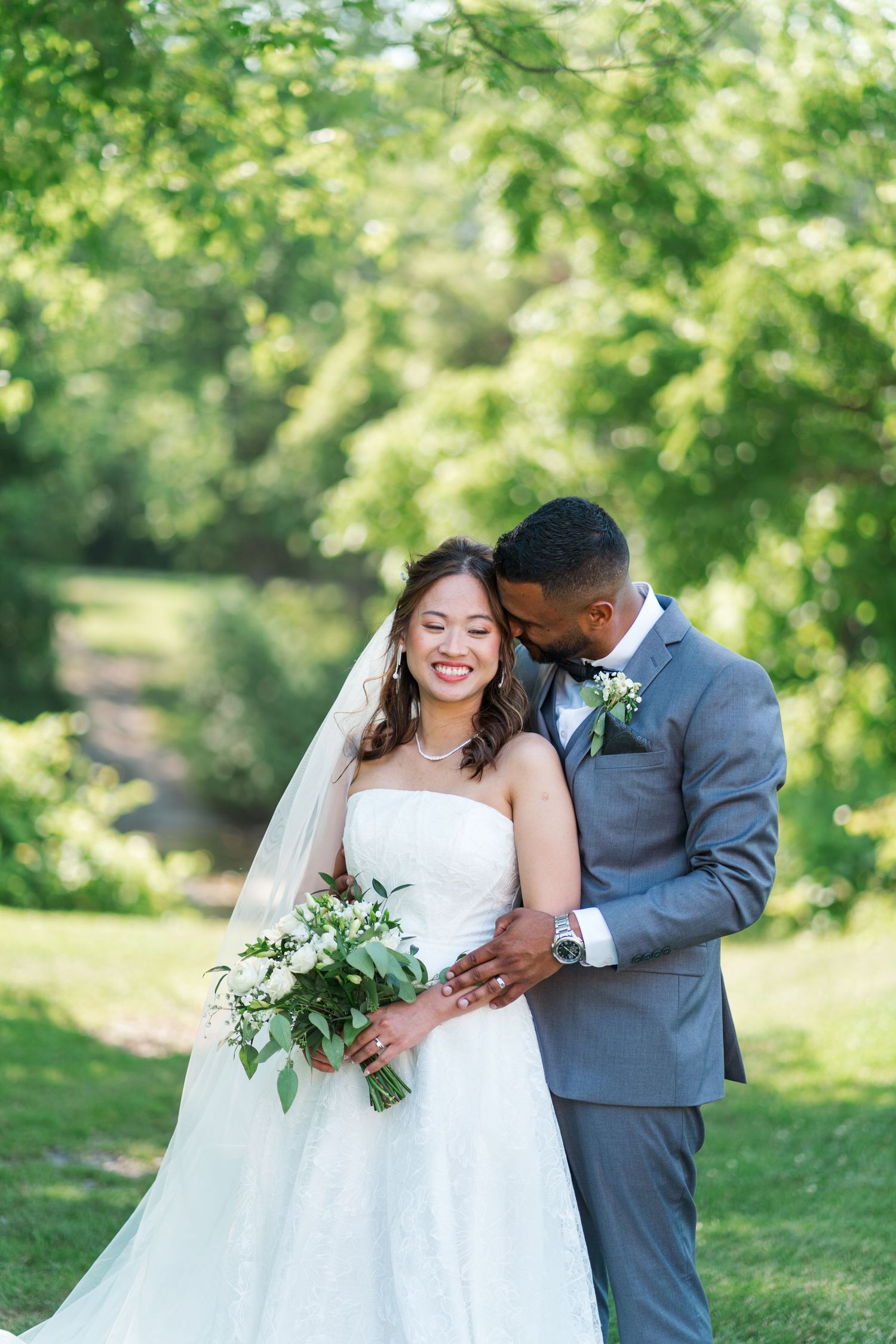Wedding couple shares intimate moment in formal attire outdoors in sunlit garden setting.
Niagara Wedding photography.