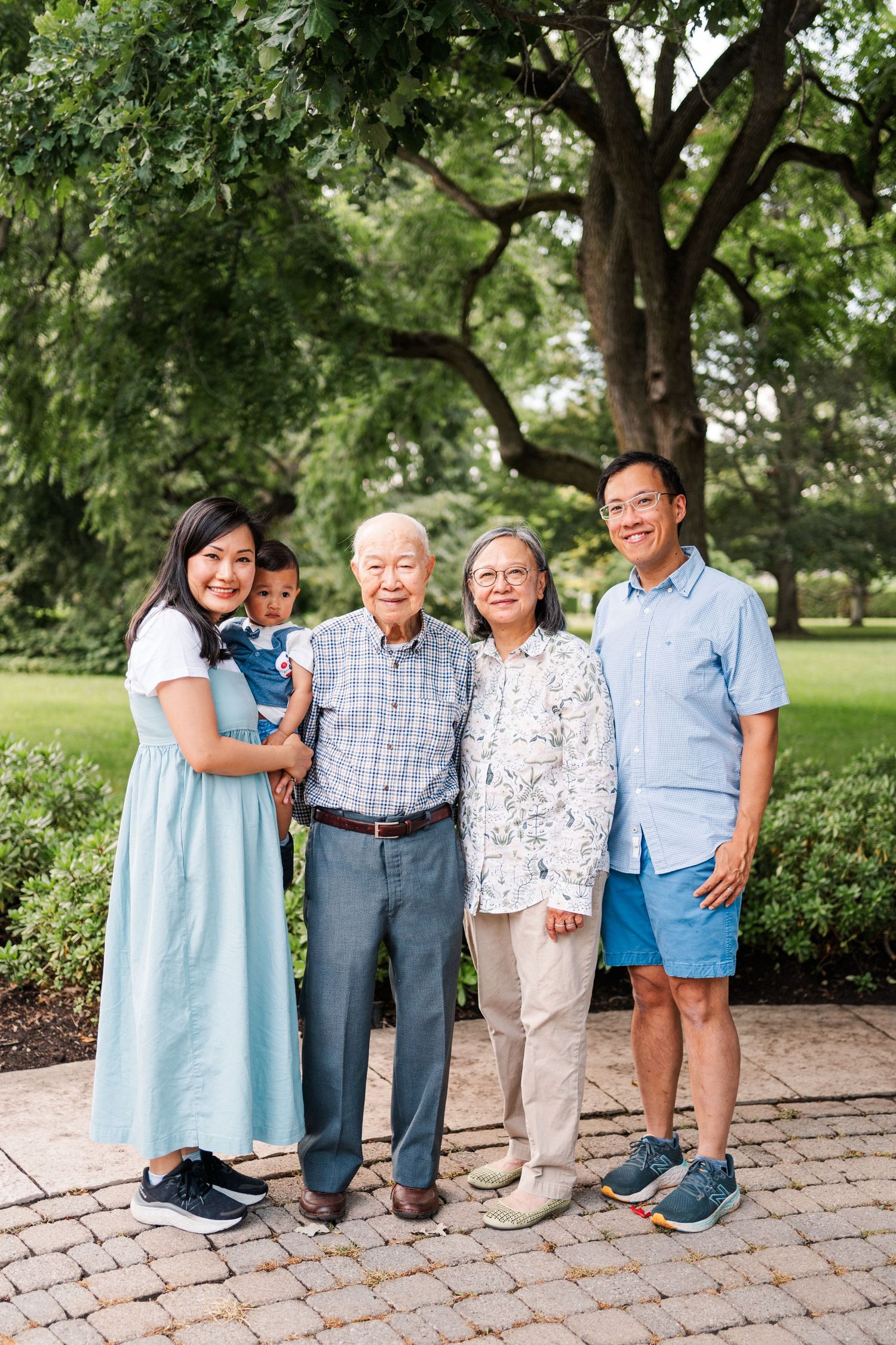 Multi-generational family poses together on stone pavers in a garden setting.
Family photos in Niagara