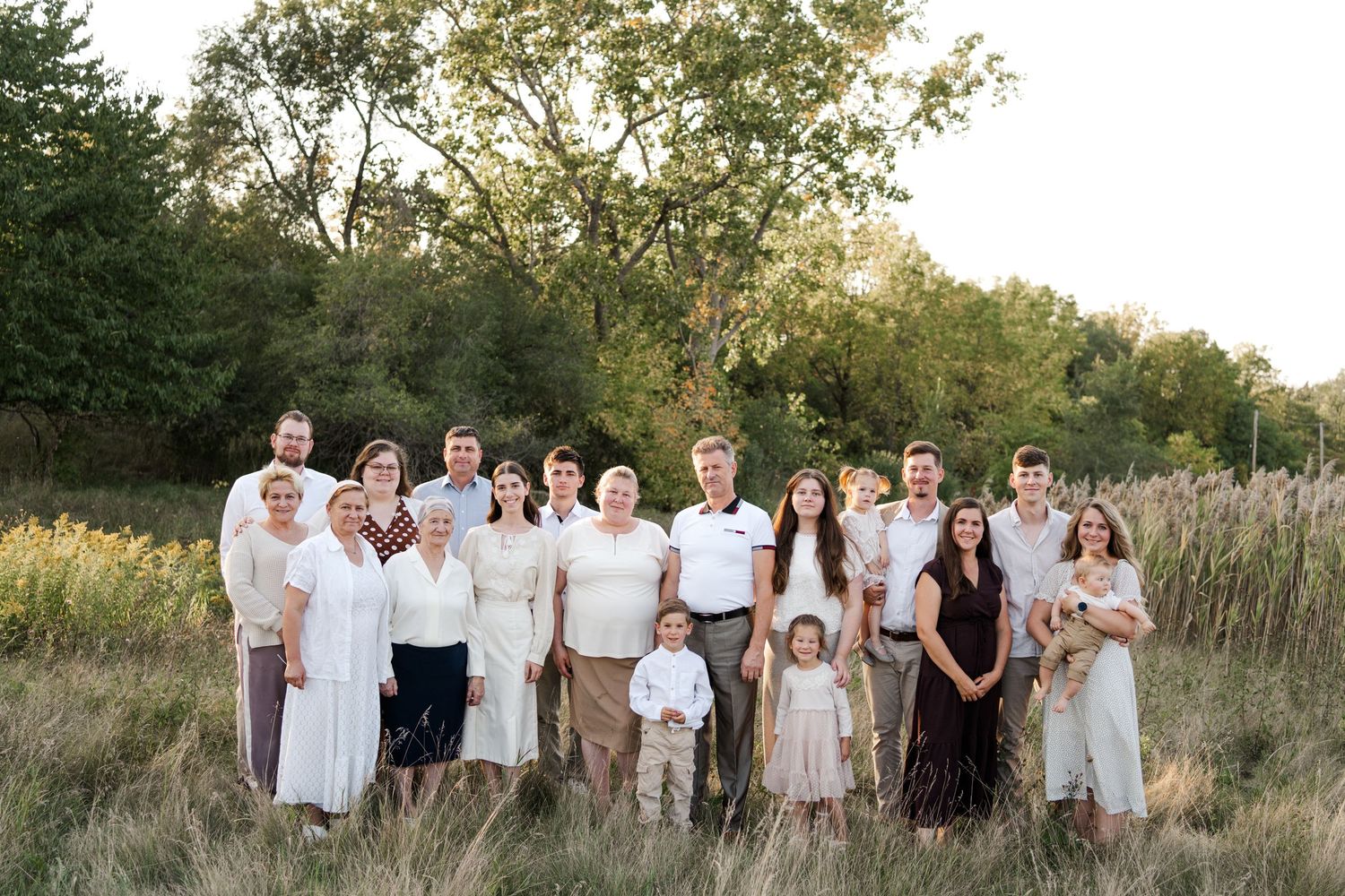 Extended family portrait session in coordinated outfits against tall grass at golden hour.
Niagara family photos.