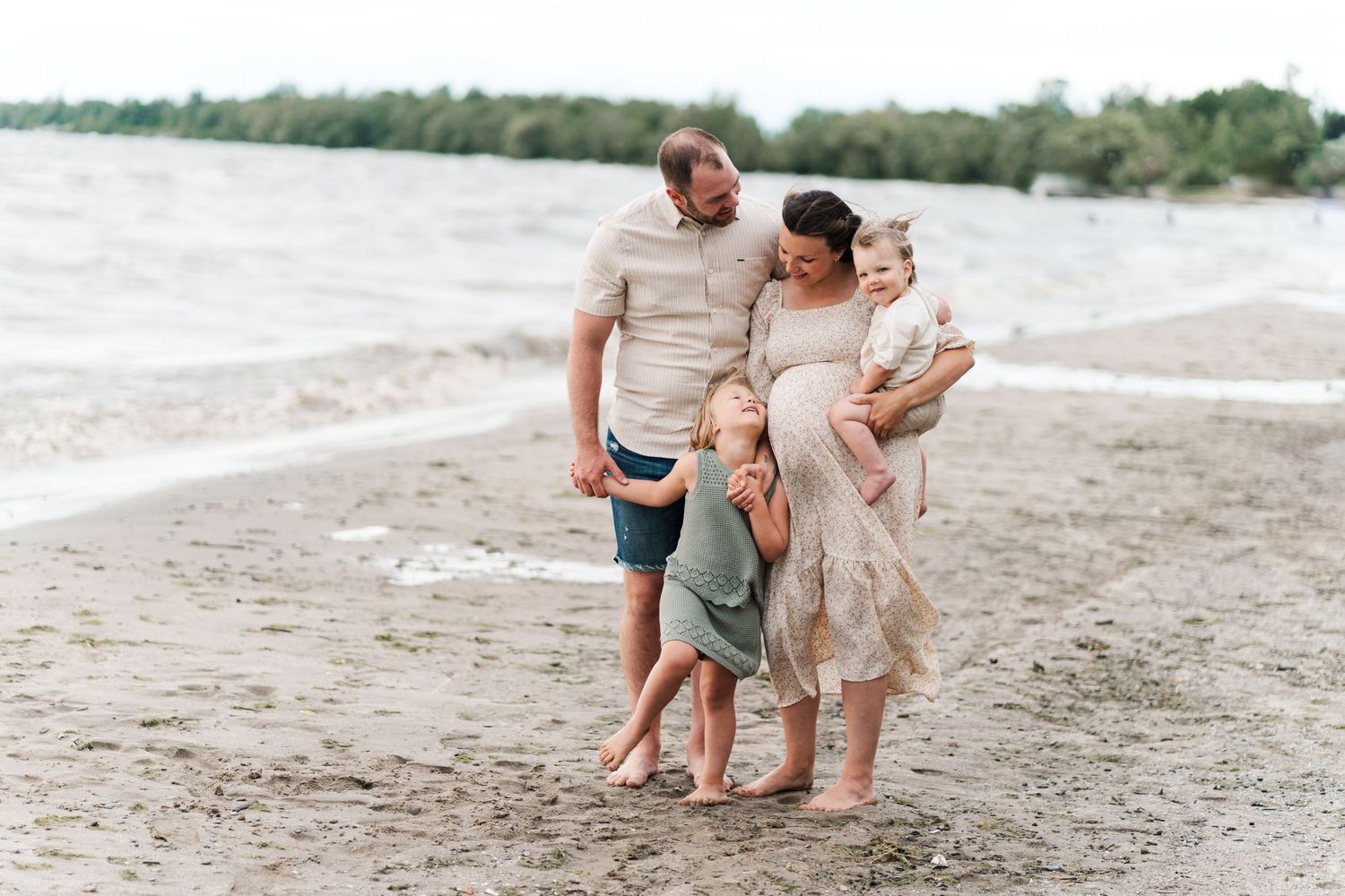 Family enjoying time together on sandy beach near water.
Niagara family photos.