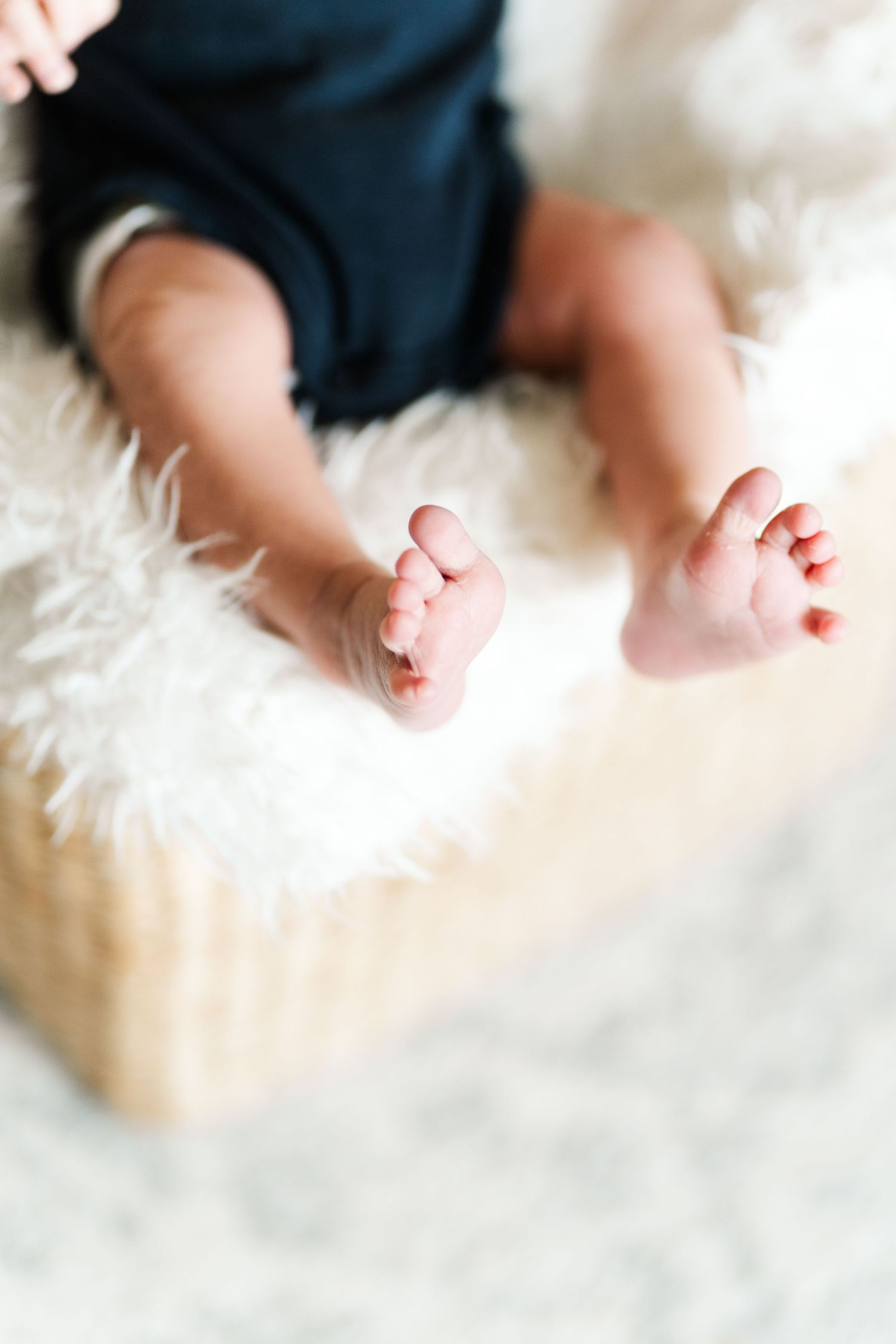Close up of tiny baby feet against white furry background.
Niagara newborn photos.