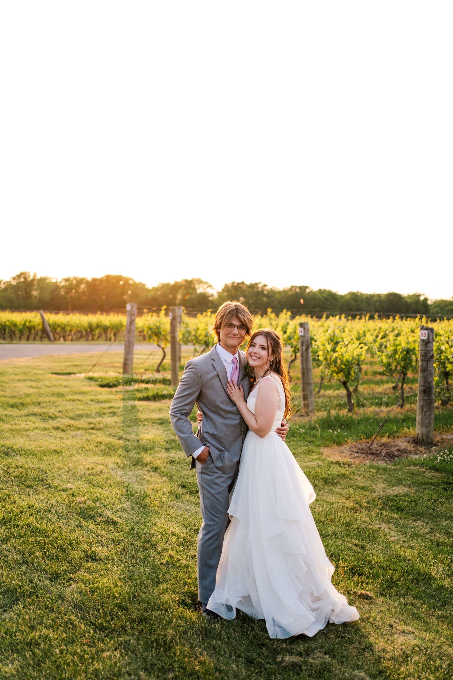 Sunset portrait of couple in vineyard with elegant wedding attire.
Niagara wedding photos.