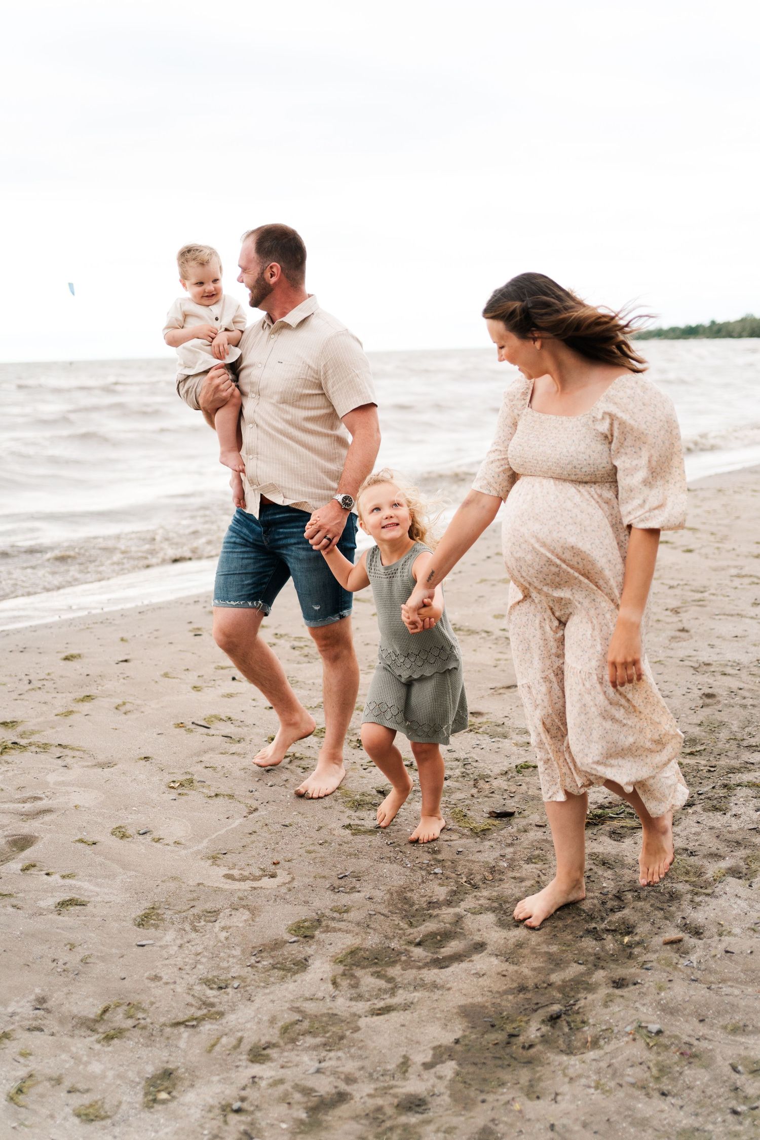 Happy family enjoying a beach walk together in coordinated neutral outfits.
Niagara wedding photos