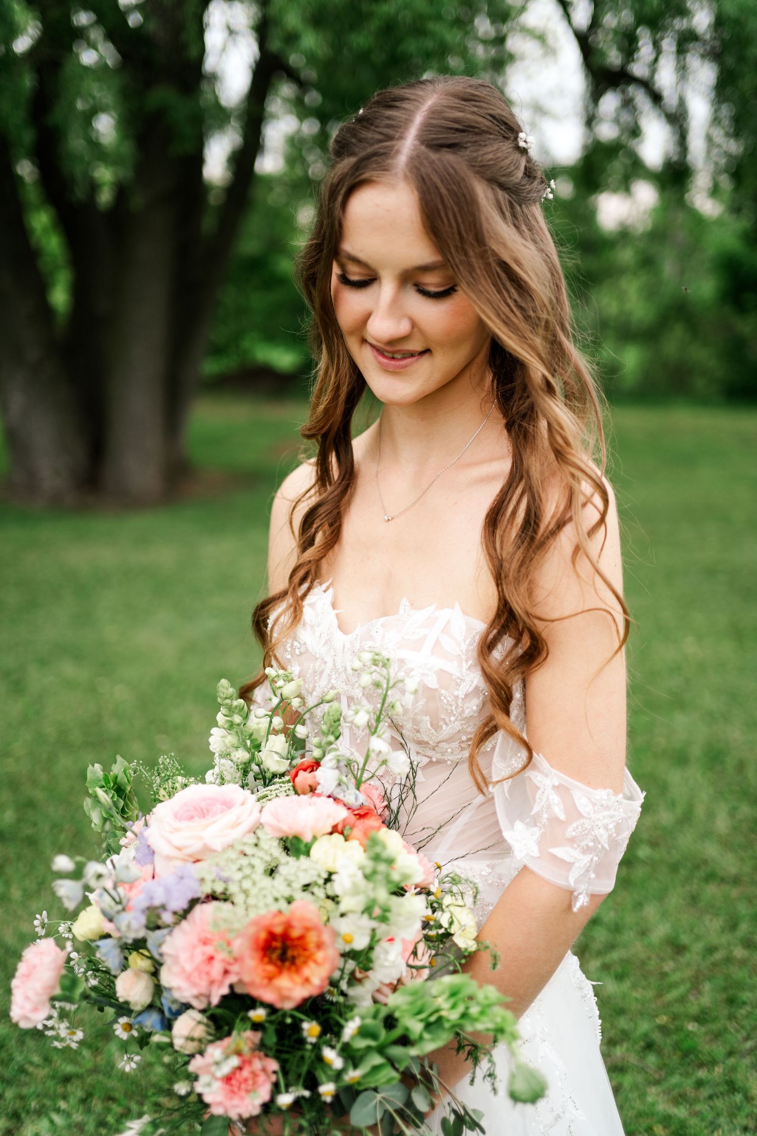 Bride holding colorful bouquet of pink and peach flowers in garden setting.

Niagara wedding photos.