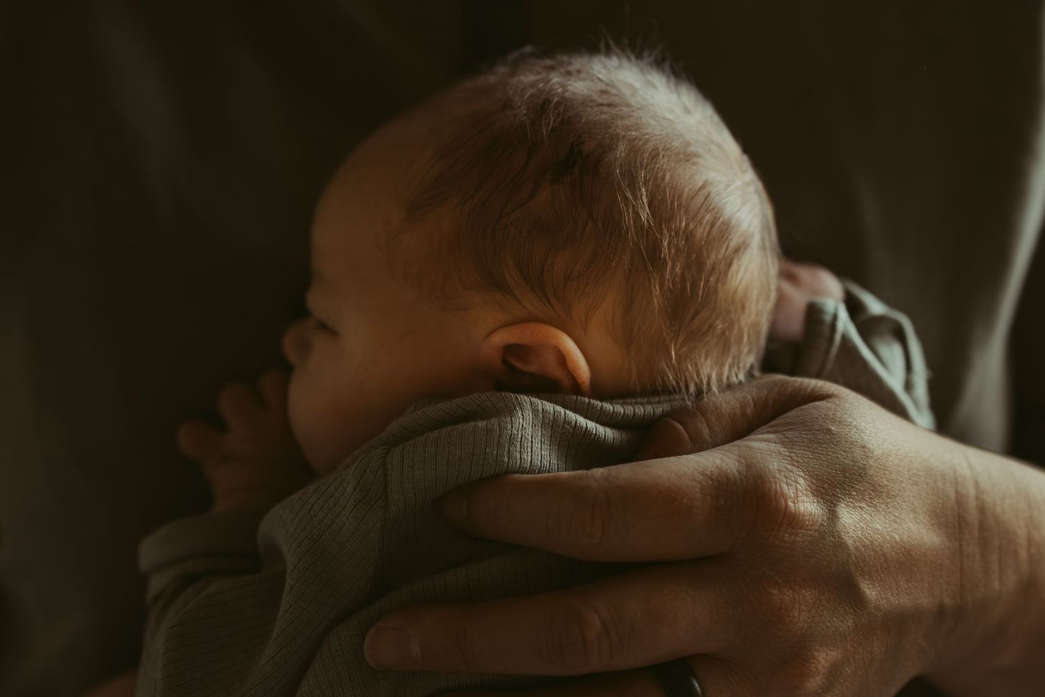 Intimate close-up photography in moody, dark lighting.