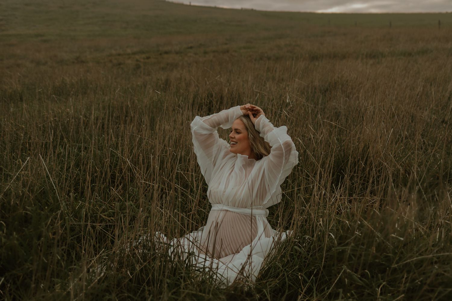 A whimsical portrait in a field of tall grass during golden hour.