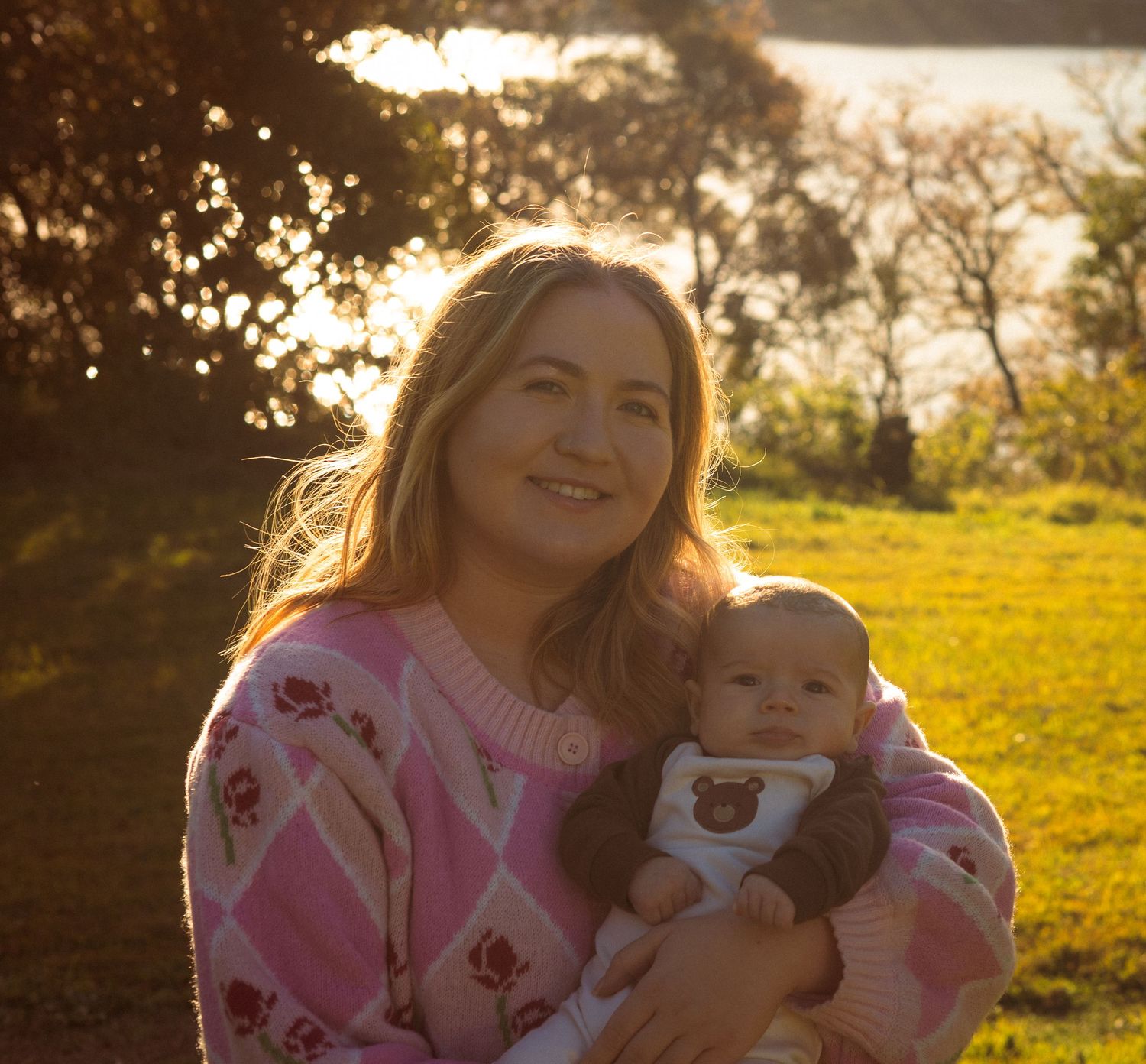 A series of sunset photos showing a person in a pink sweater holding a baby against a golden backlit field.