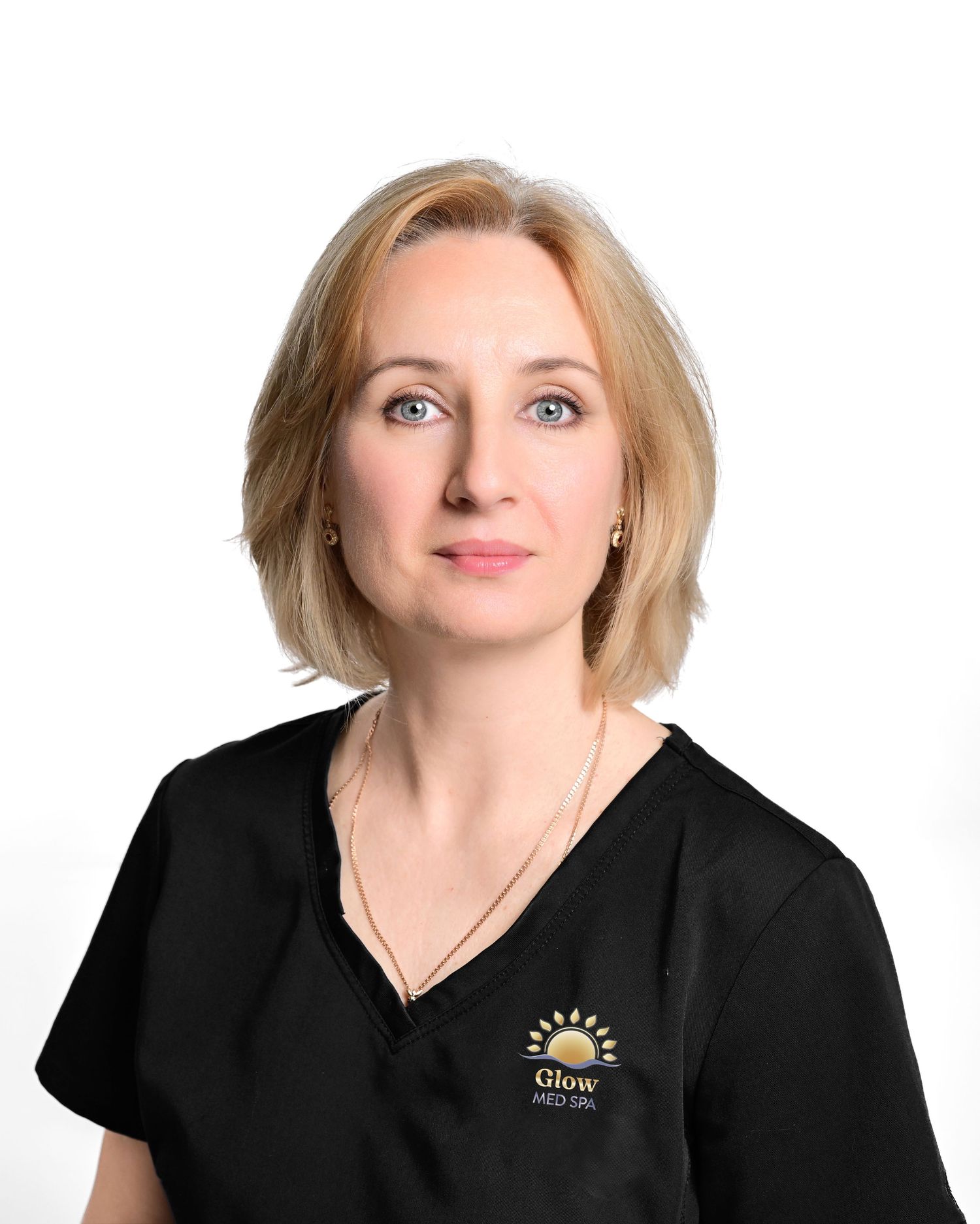 Medical professional wearing black Glow Med Spa scrubs in a clean professional headshot portrait.