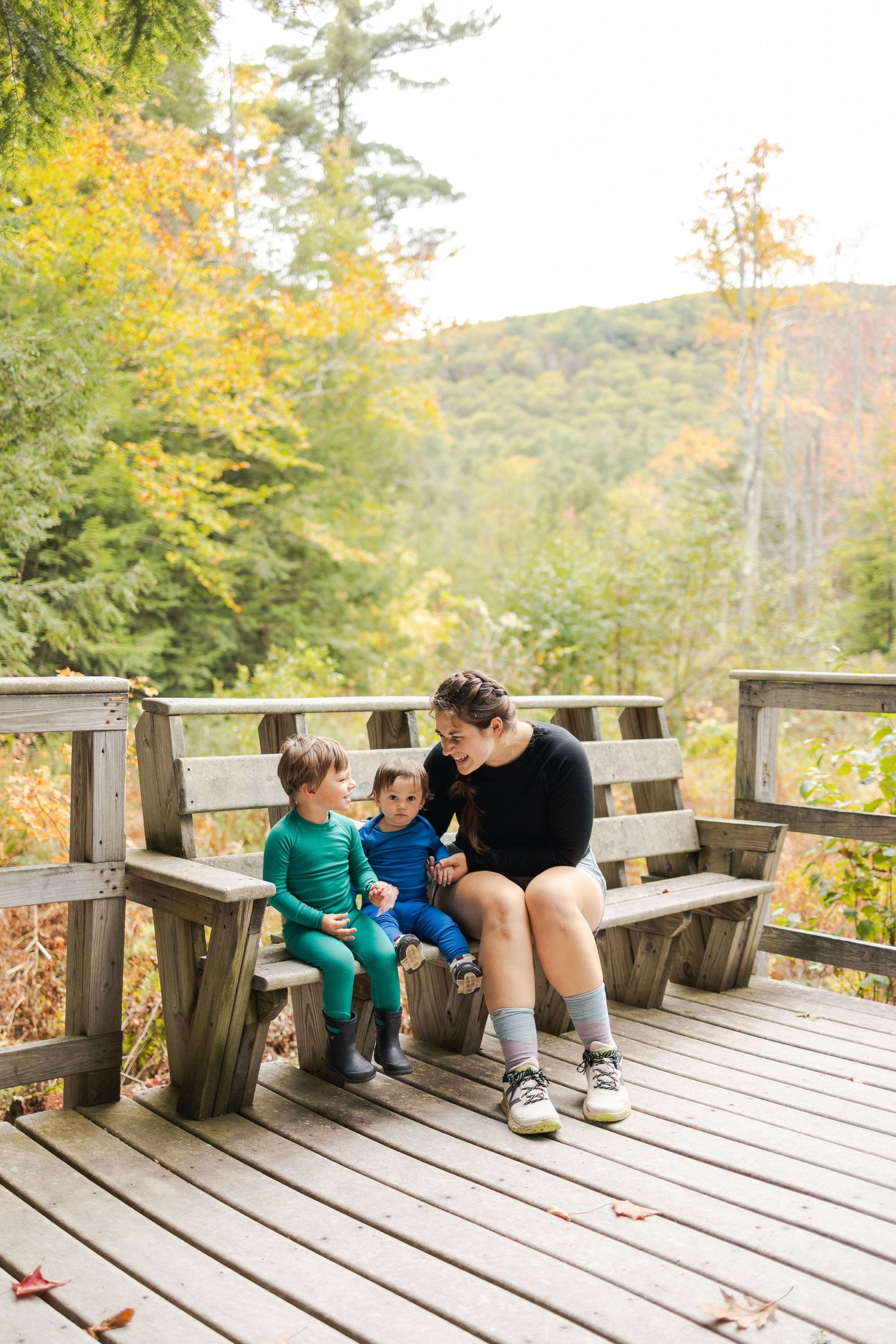 Outdoor fall image of mom and two kids on bench