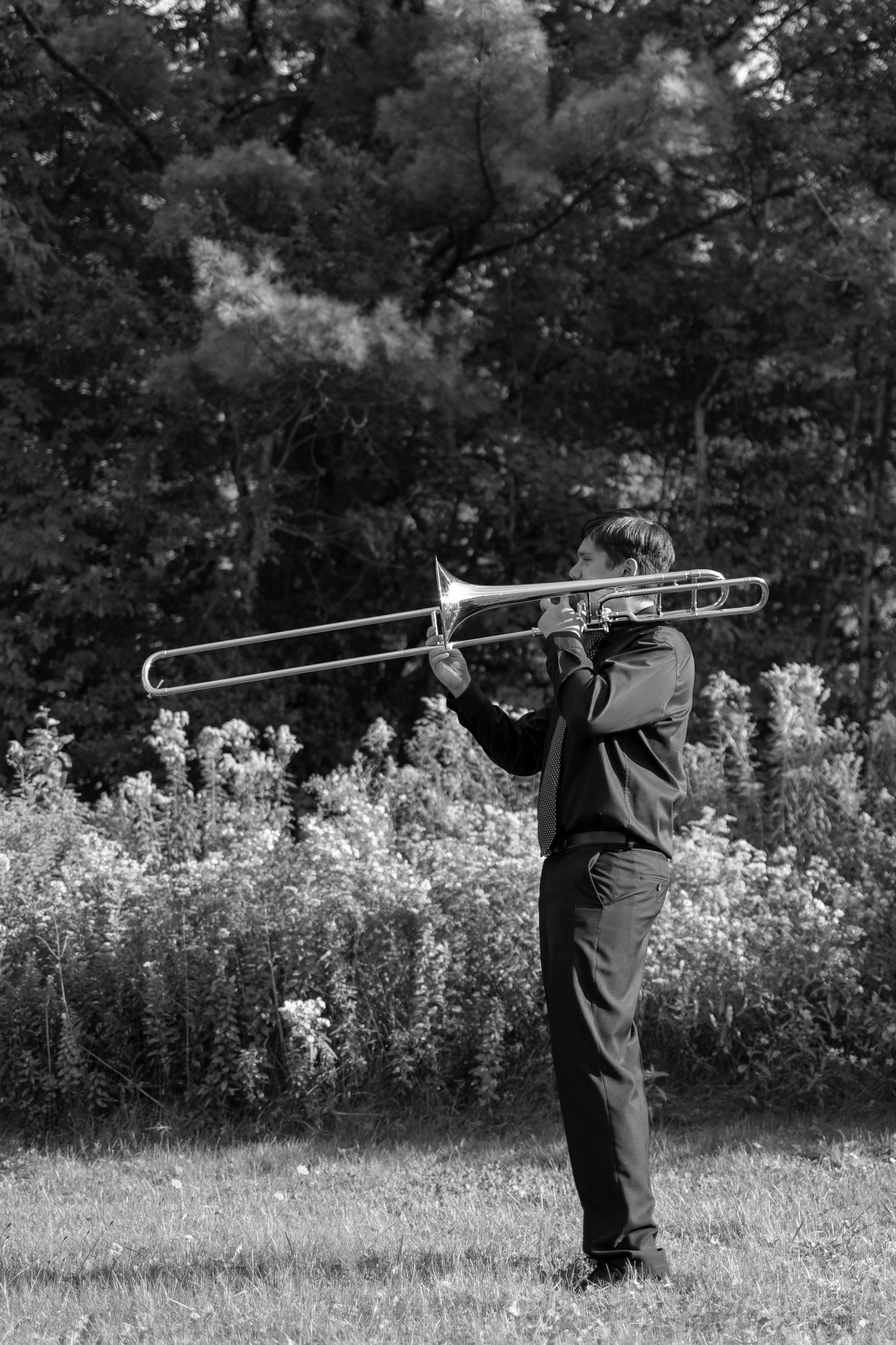 Black and white image of young man playing trombone