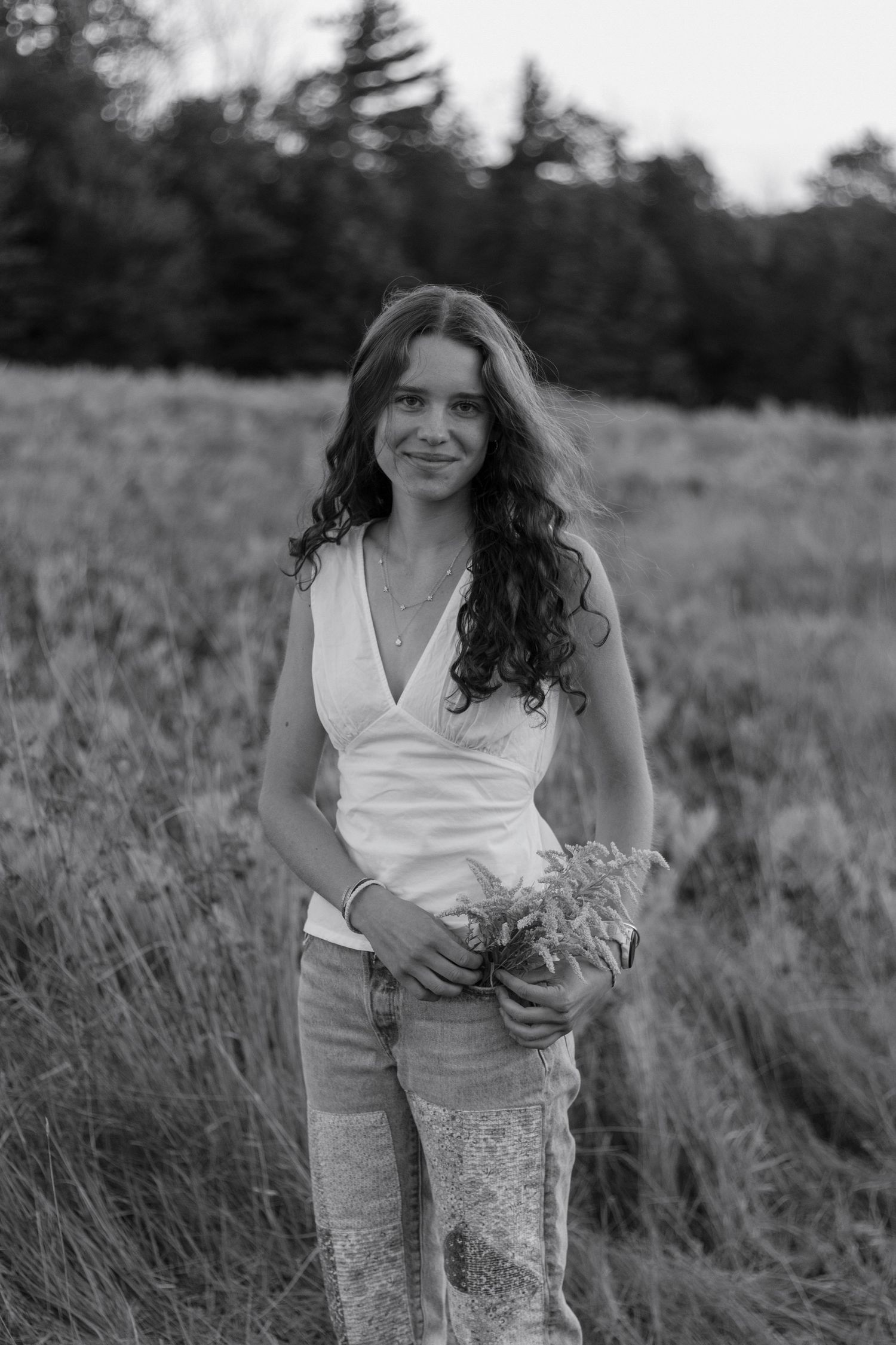Black and white senior photo in field