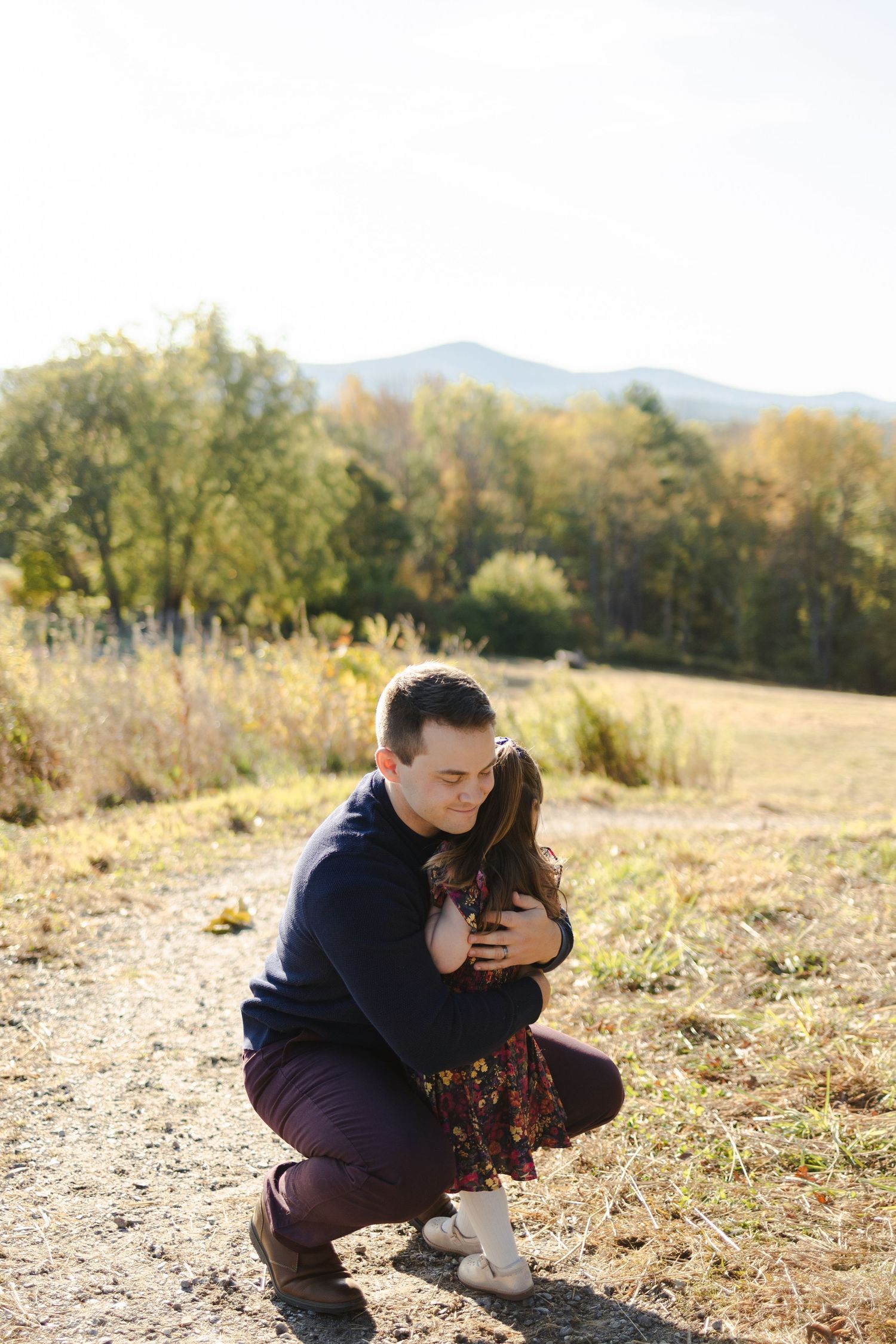 Outdoor portrait of dad hugging toddler