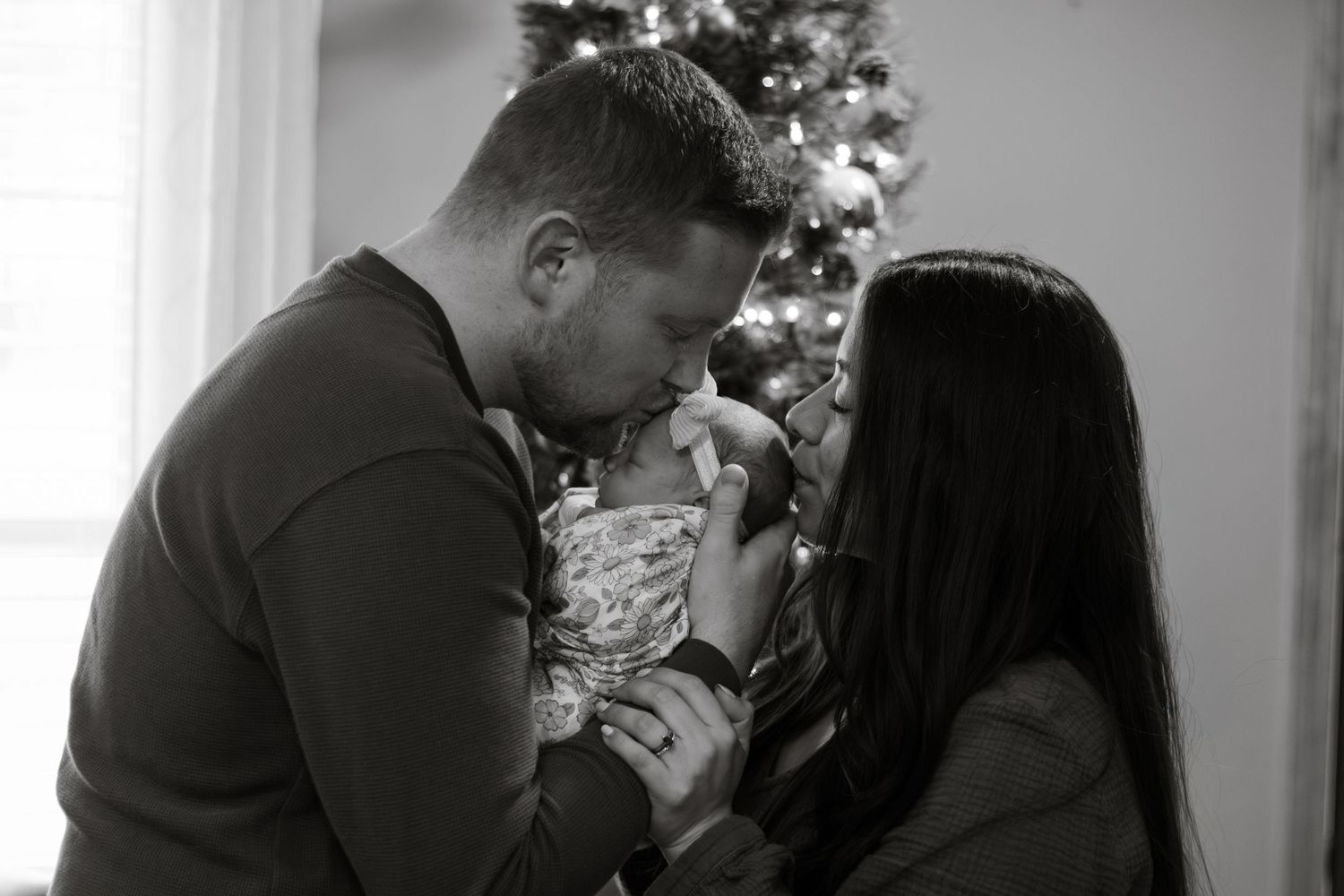 Black and white image of couple with newborn
