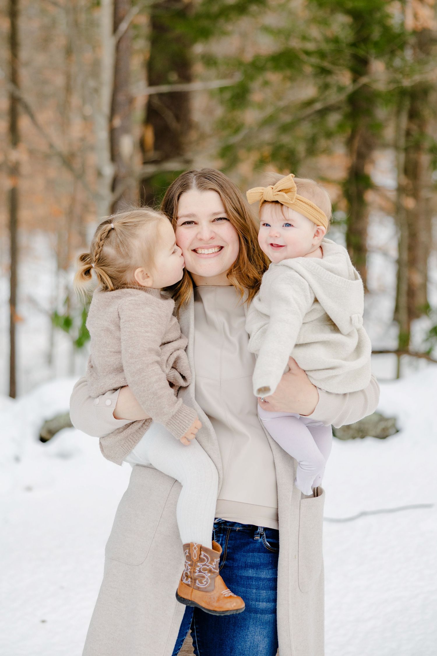 Mom holding two daughters outside