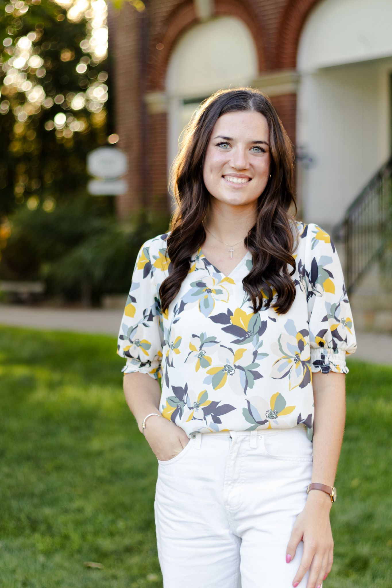 A series of outdoor photos showing someone wearing a yellow floral print top and white pants.