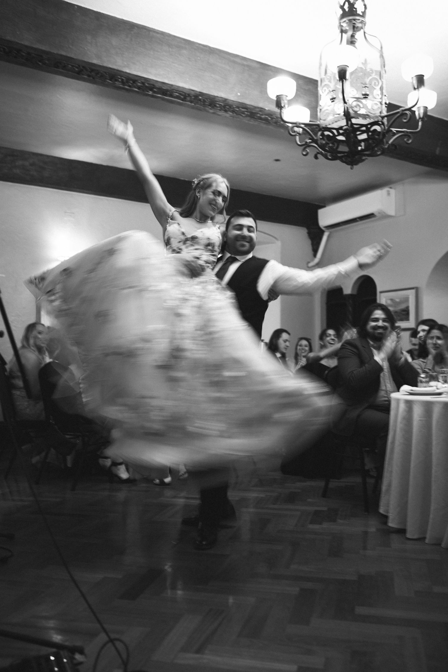 A sequence of black and white photos showing someone falling backwards during a dance move at a formal event.