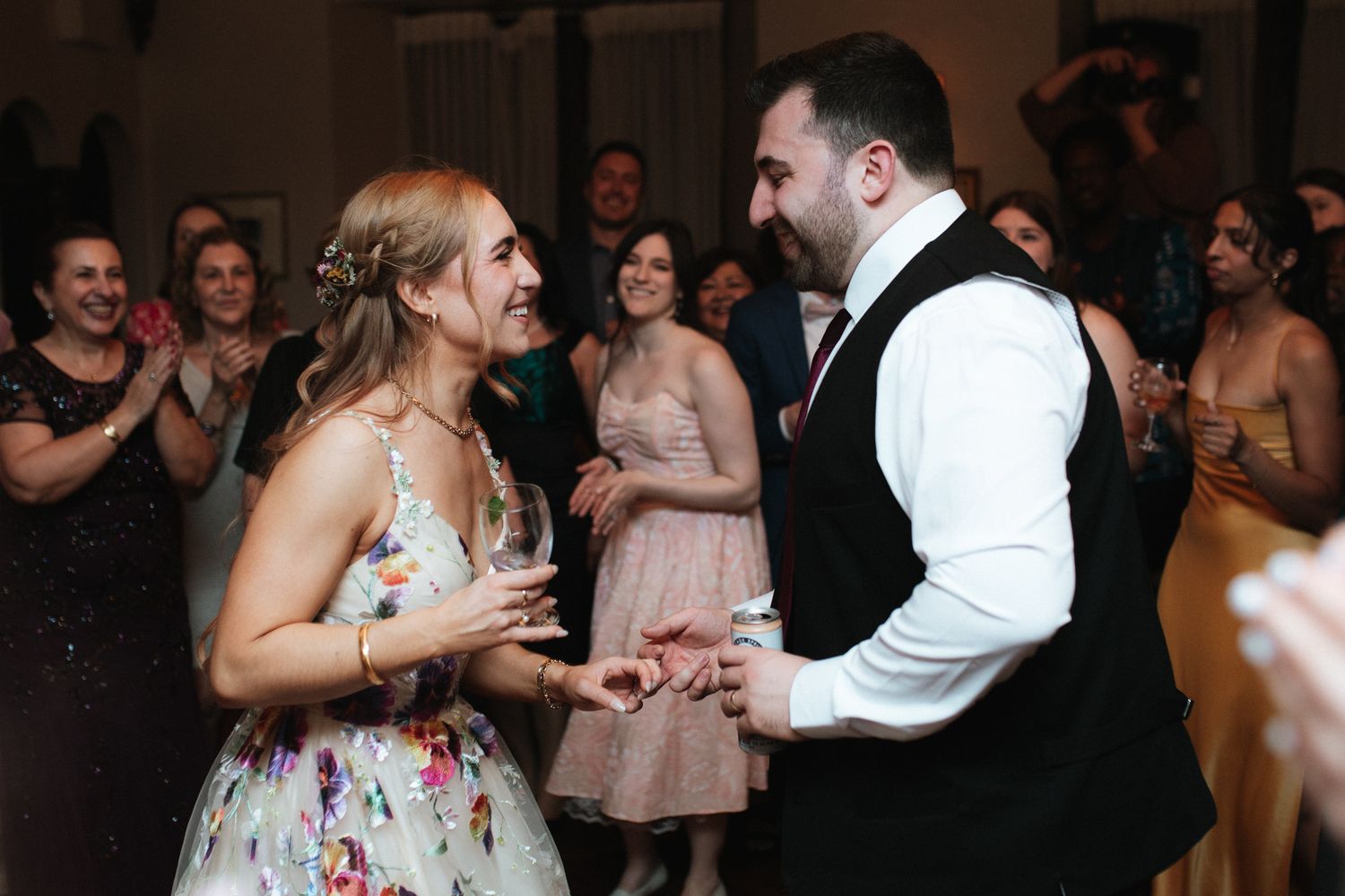 Wedding guests share a joyful moment dancing together on the dance floor at a reception celebration.