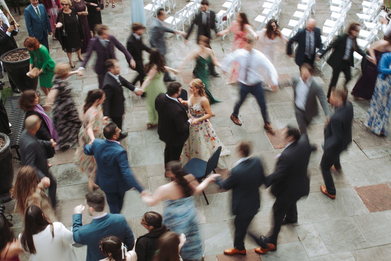 Blurred motion of people dancing together in a large indoor space during a social dance event.