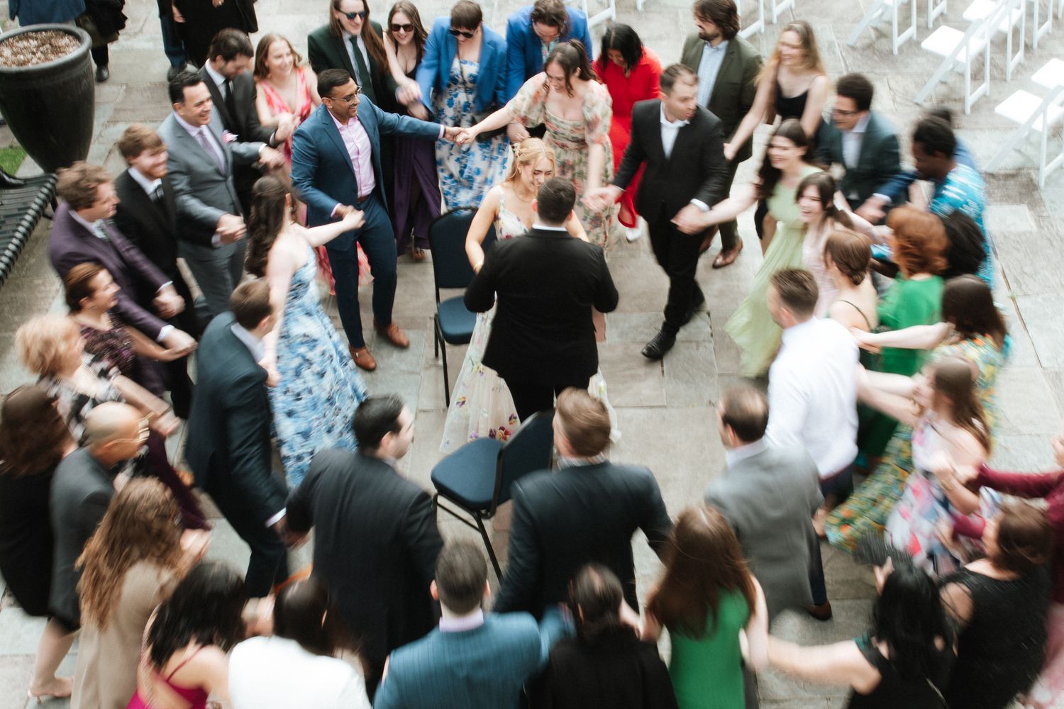 Overhead view of people mingling and socializing at a formal indoor event with tables and chairs.