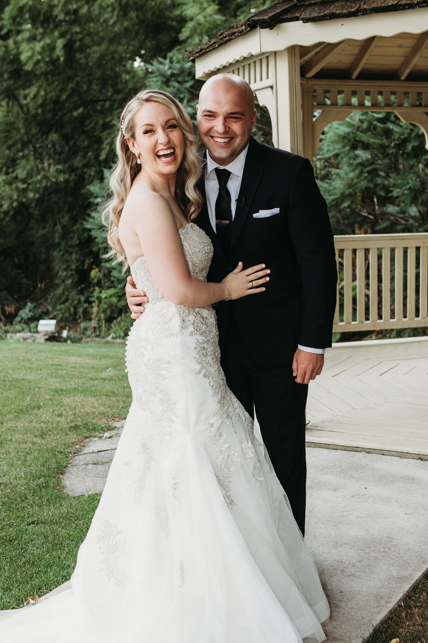 A joyful wedding couple shares an intimate moment together outdoors on their special day.