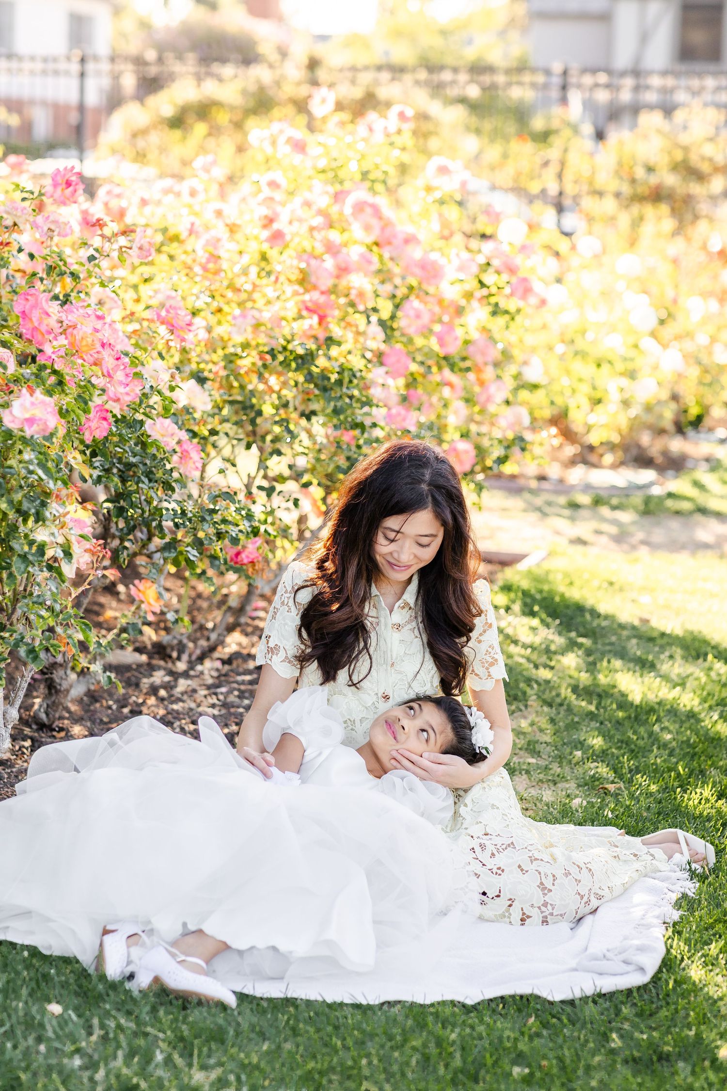 A serene garden scene with white lace dresses and pink roses creating a romantic outdoor setting.