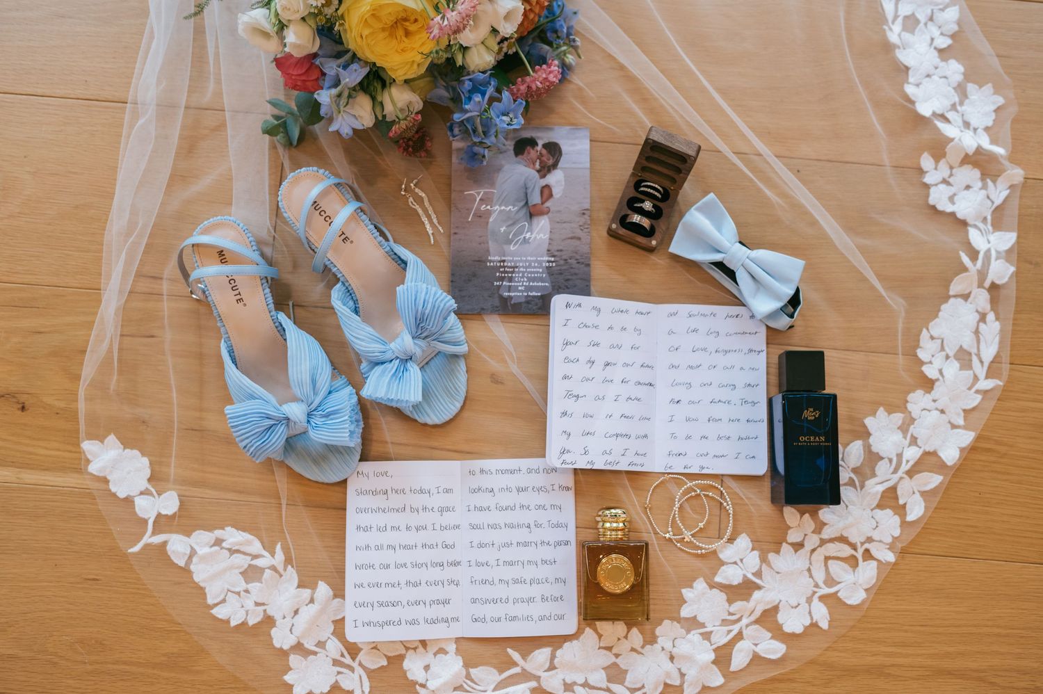 Wedding flat lay with blue heels, vows journal, bow tie, and floral veil on wood floor, wedding photographer Asheboro NC