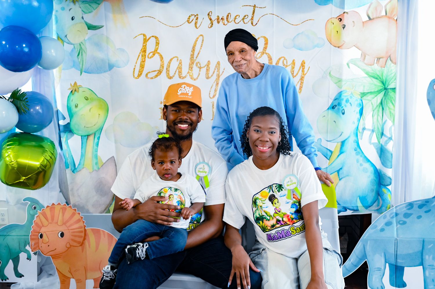 Family of four with elderly guest at a sweet baby boy dinosaur birthday party.