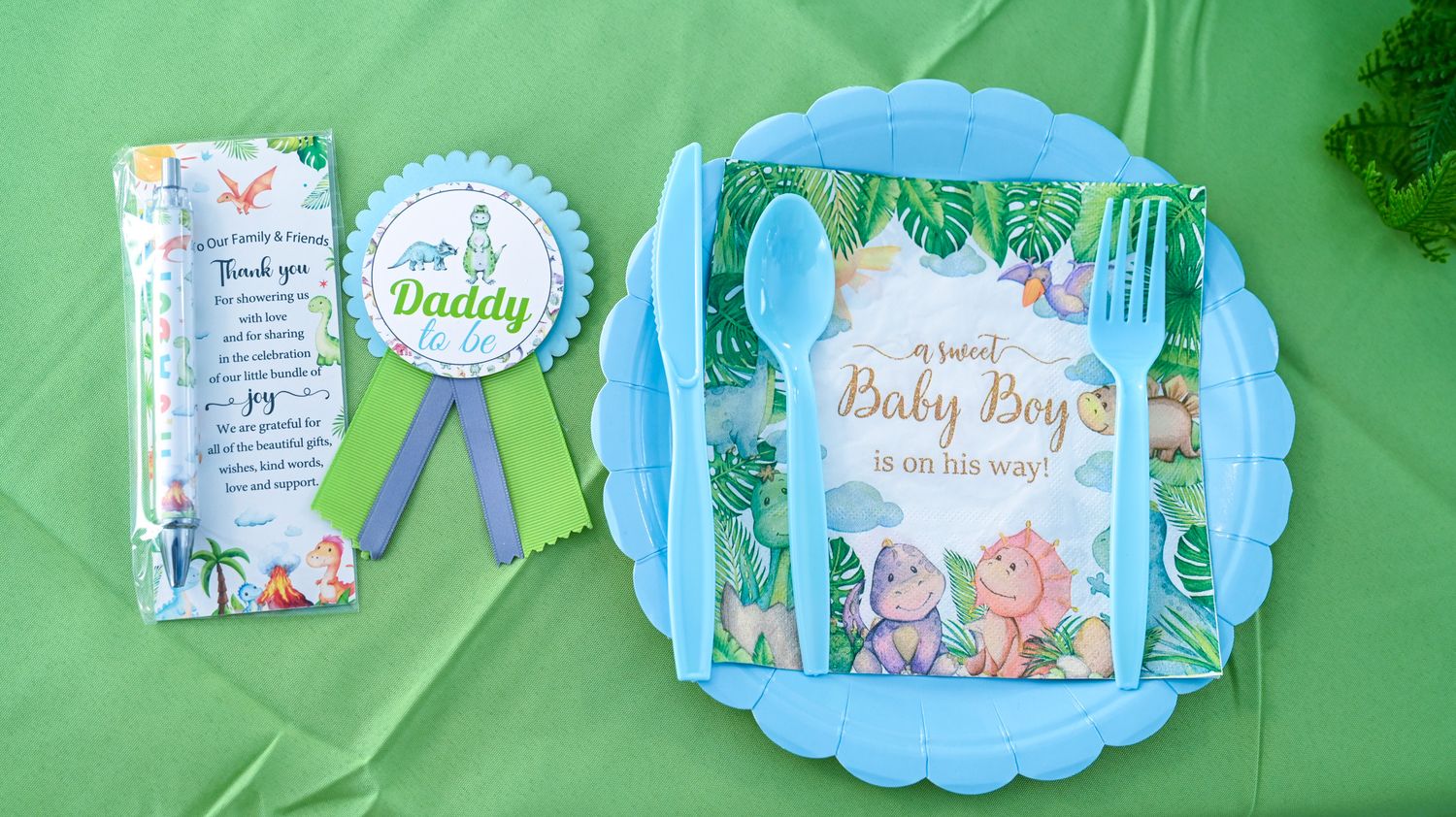 Daddy baby boy dinosaur shower place setting with blue plate and ribbon badge.