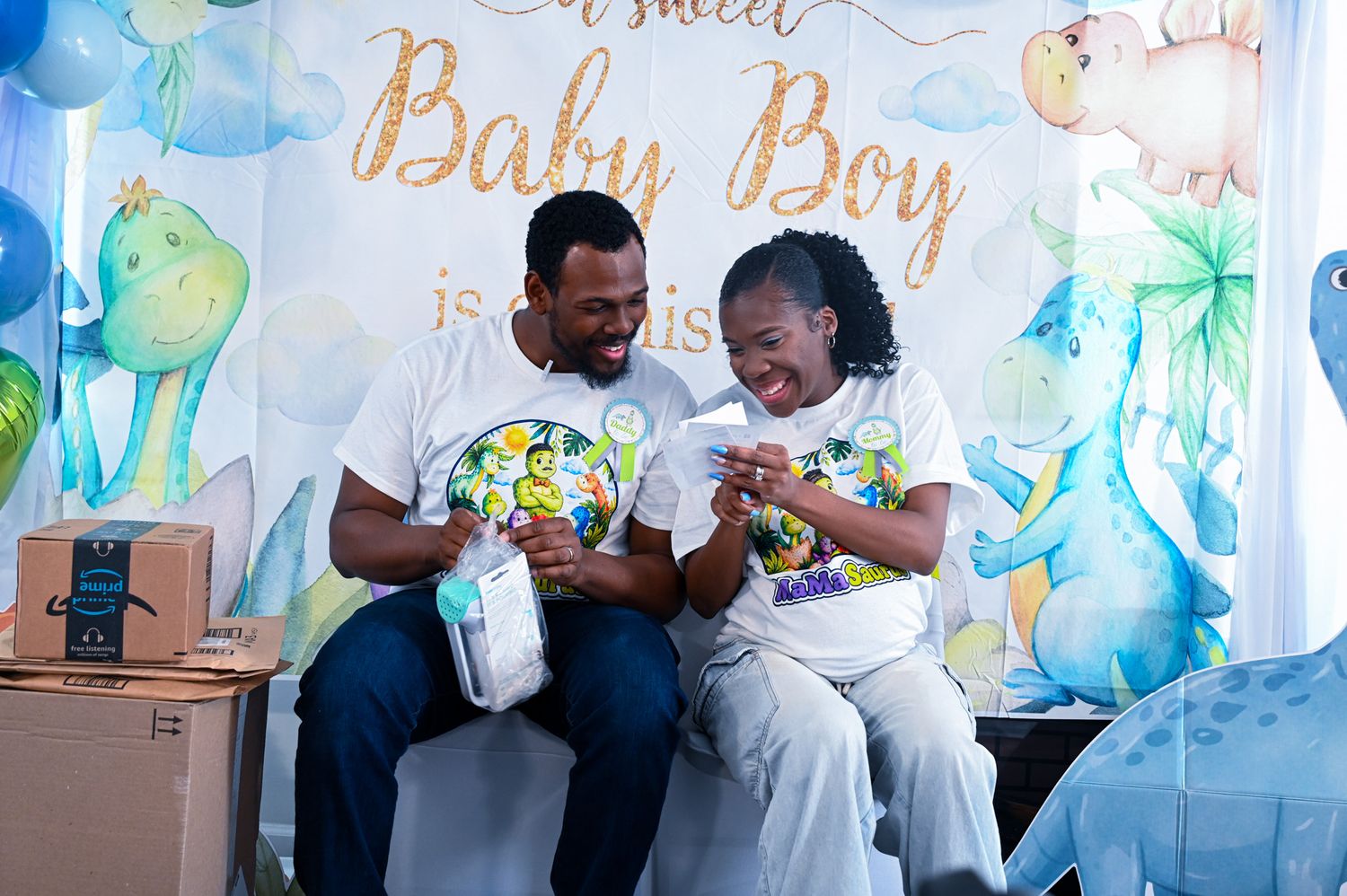 Happy couple laughing together while opening baby gifts at a sweet Baby Boy shower.