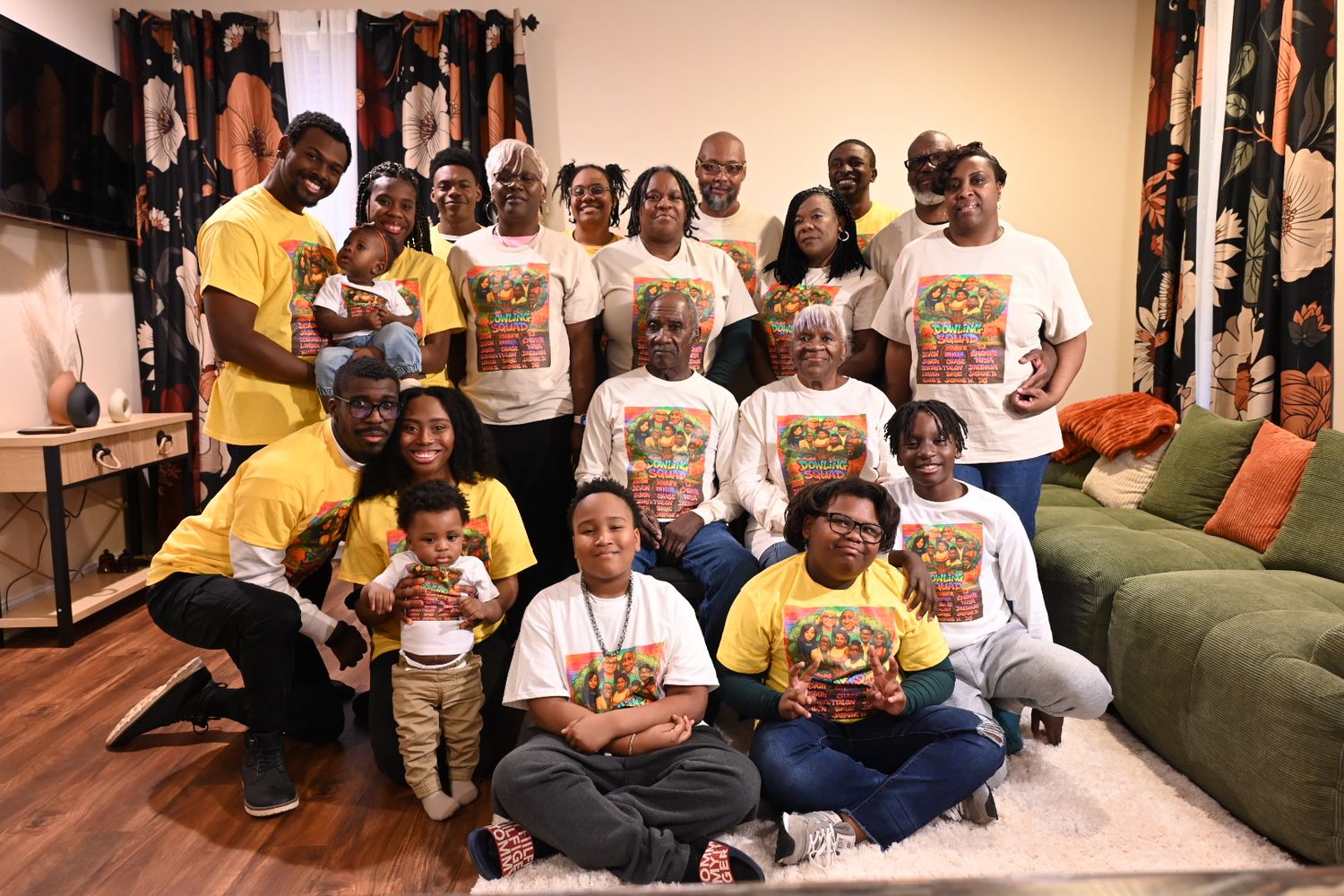Large family group photo with adults and children wearing matching yellow and white shirts, posing together indoors.