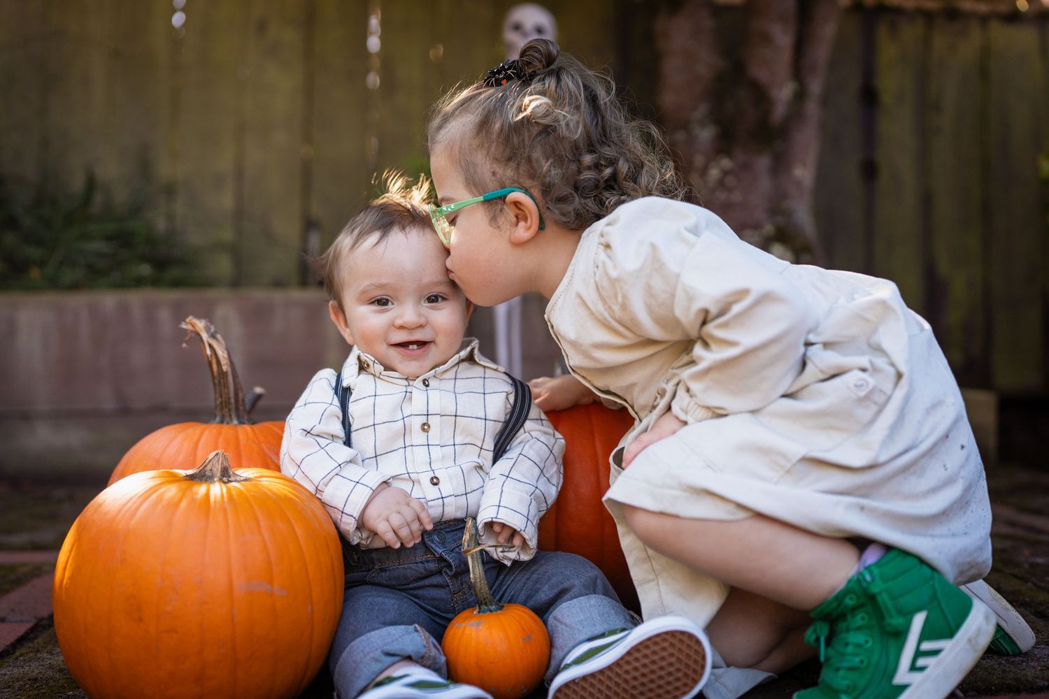 A sequence of six photos showing children and adults interacting with pumpkins in an outdoor setting.