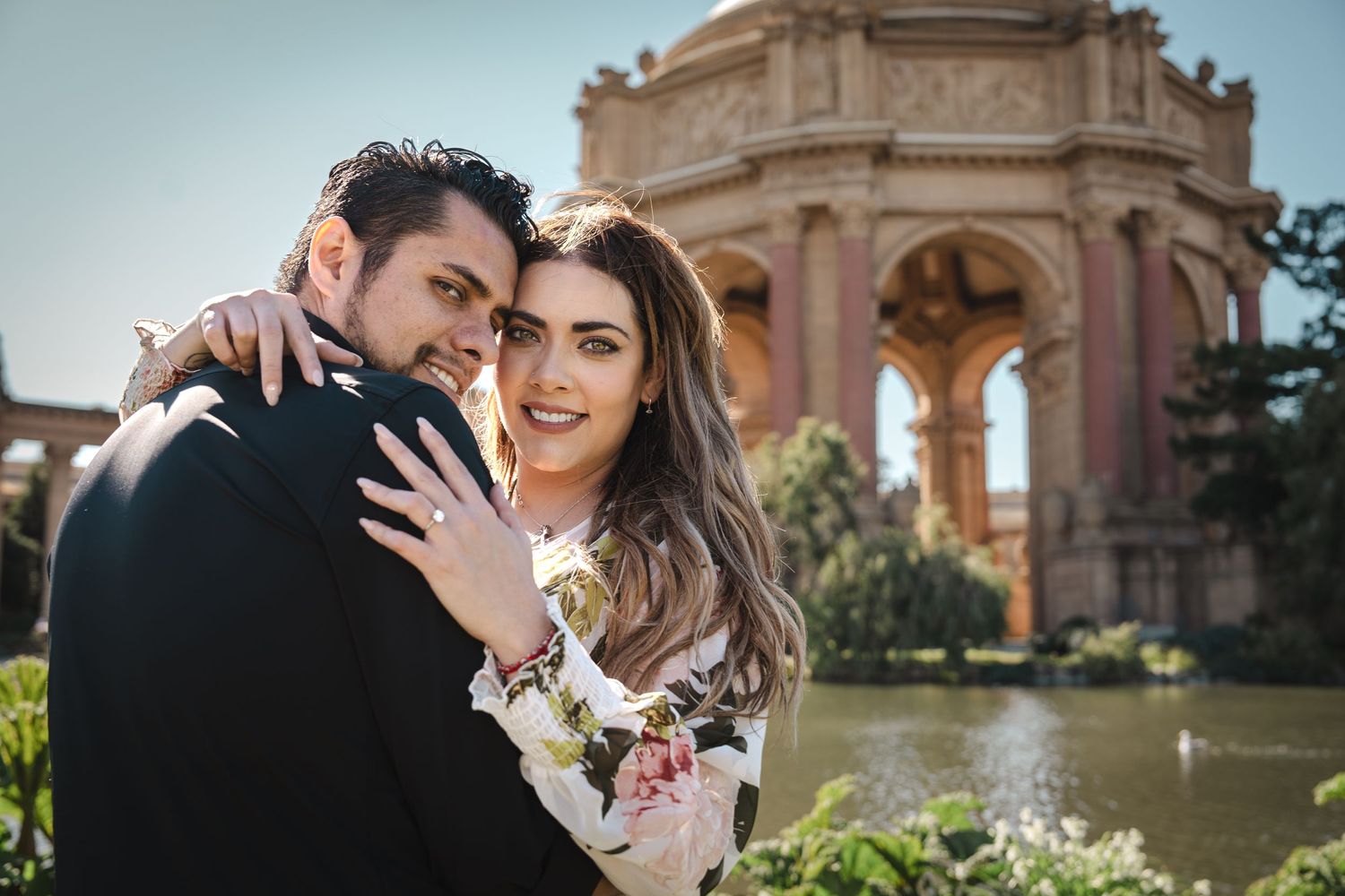 Romantic portrait of a couple embracing at the Palace of Fine Arts in San Francisco.