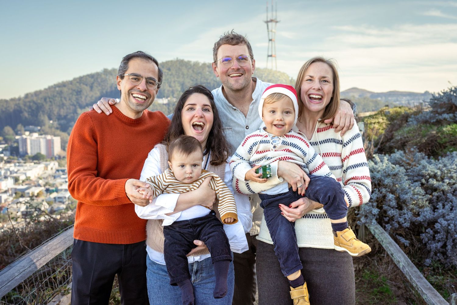 Group portrait of extended family with children on hilltop overlook.
