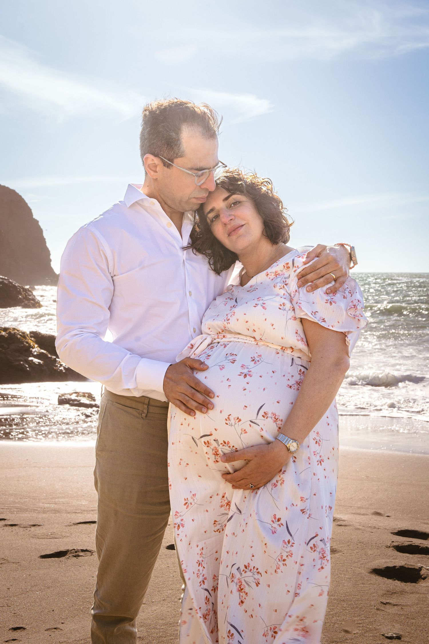 Couple sharing intimate moment on beach during sunset.