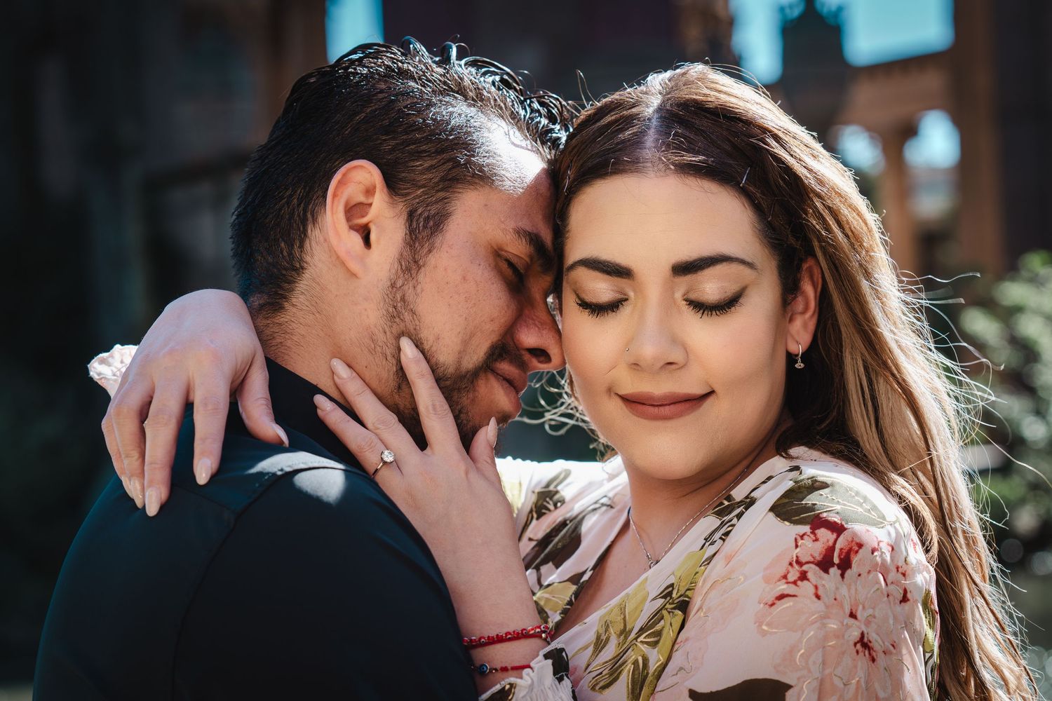 Intimate portrait of an engaged couple sharing a romantic moment outdoors.