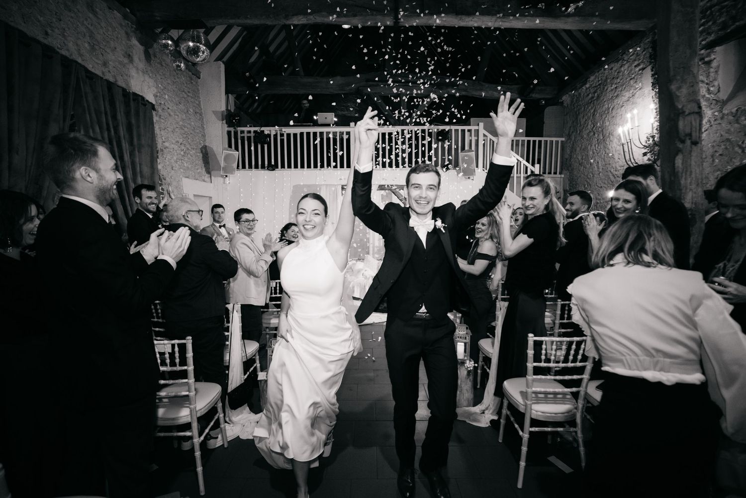 Les invités au mariage dansent et célèbrent ensemble sur une piste de danse faiblement éclairée lors d'une réception en soirée.