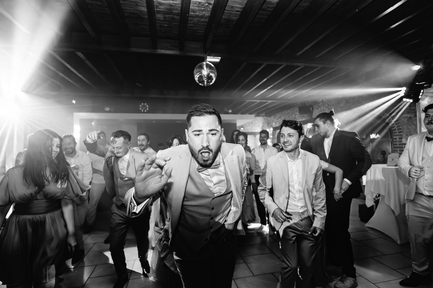 Une séquence de photos panoramiques en noir et blanc montrant des gens dansant et célébrant lors d'une fête animée.