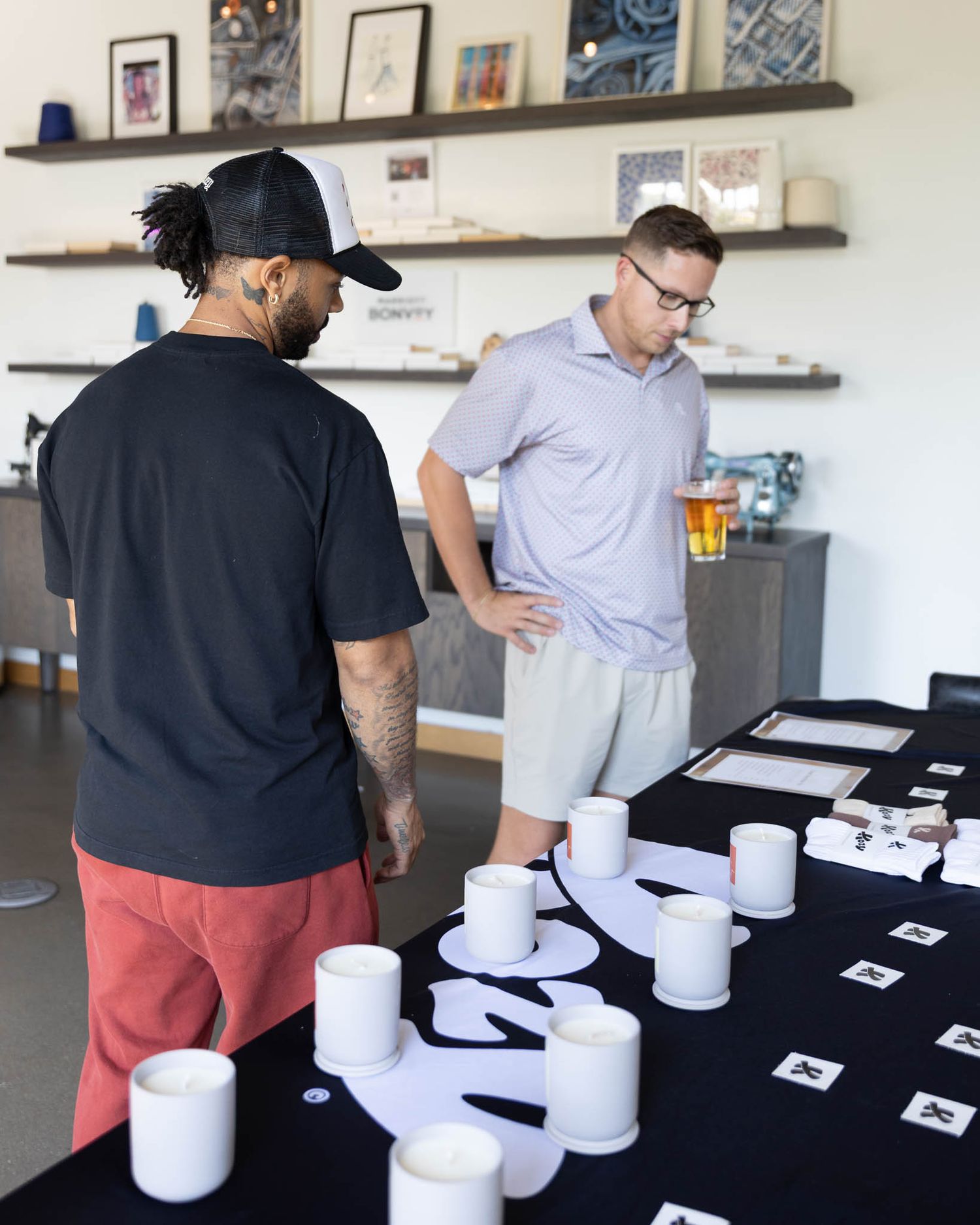 People evaluating coffee samples in white cups lined up on a black tablecloth during a professional tasting session.