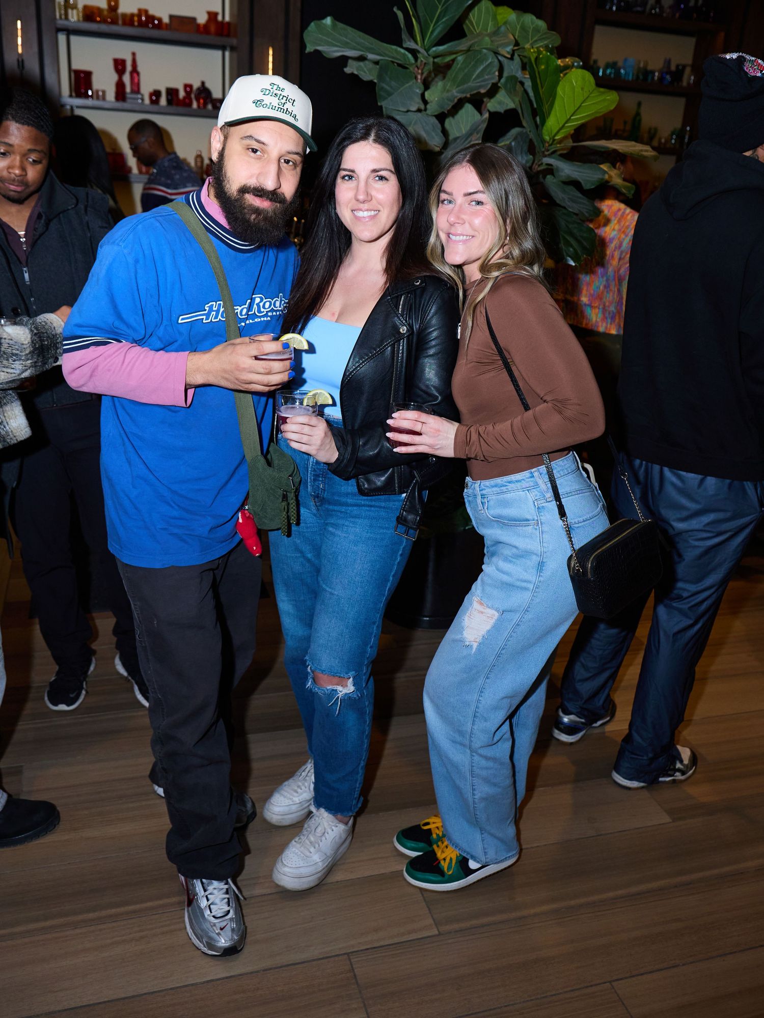 Group of friends dancing and socializing at a casual indoor gathering wearing jeans and casual attire.