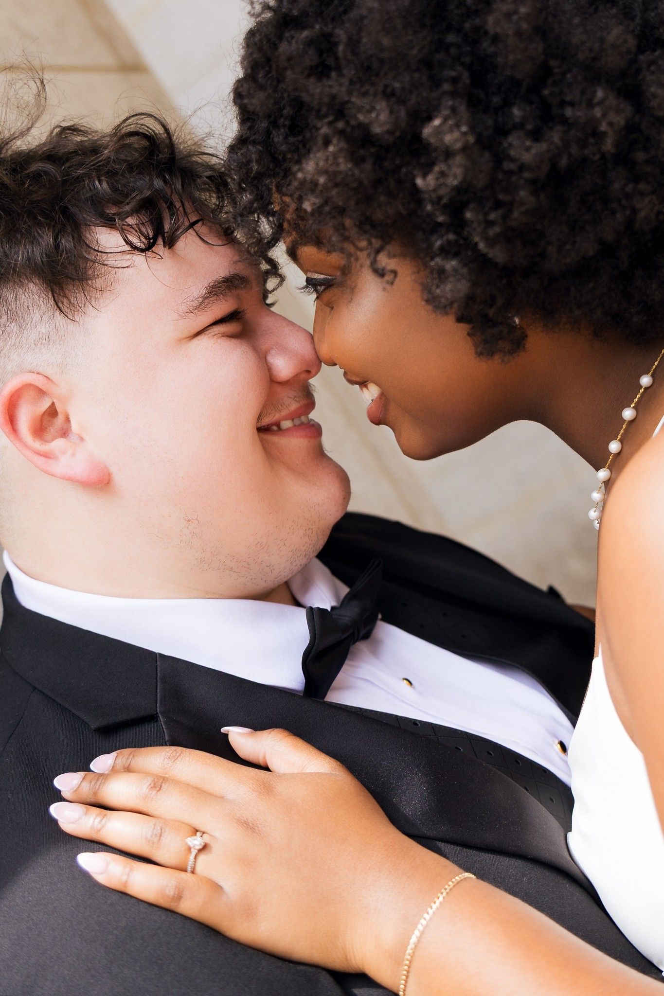 Close-up of interracial bride and groom sharing an intimate nose-to-nose moment on wedding day.
