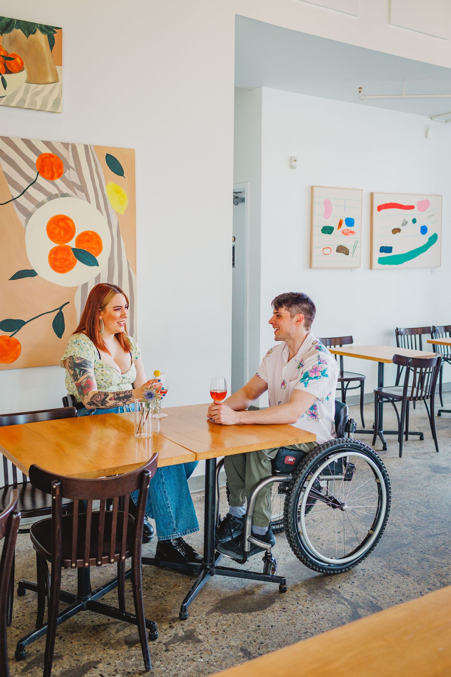 Interior of a bright cafe with modern decor and wheelchair accessible seating.