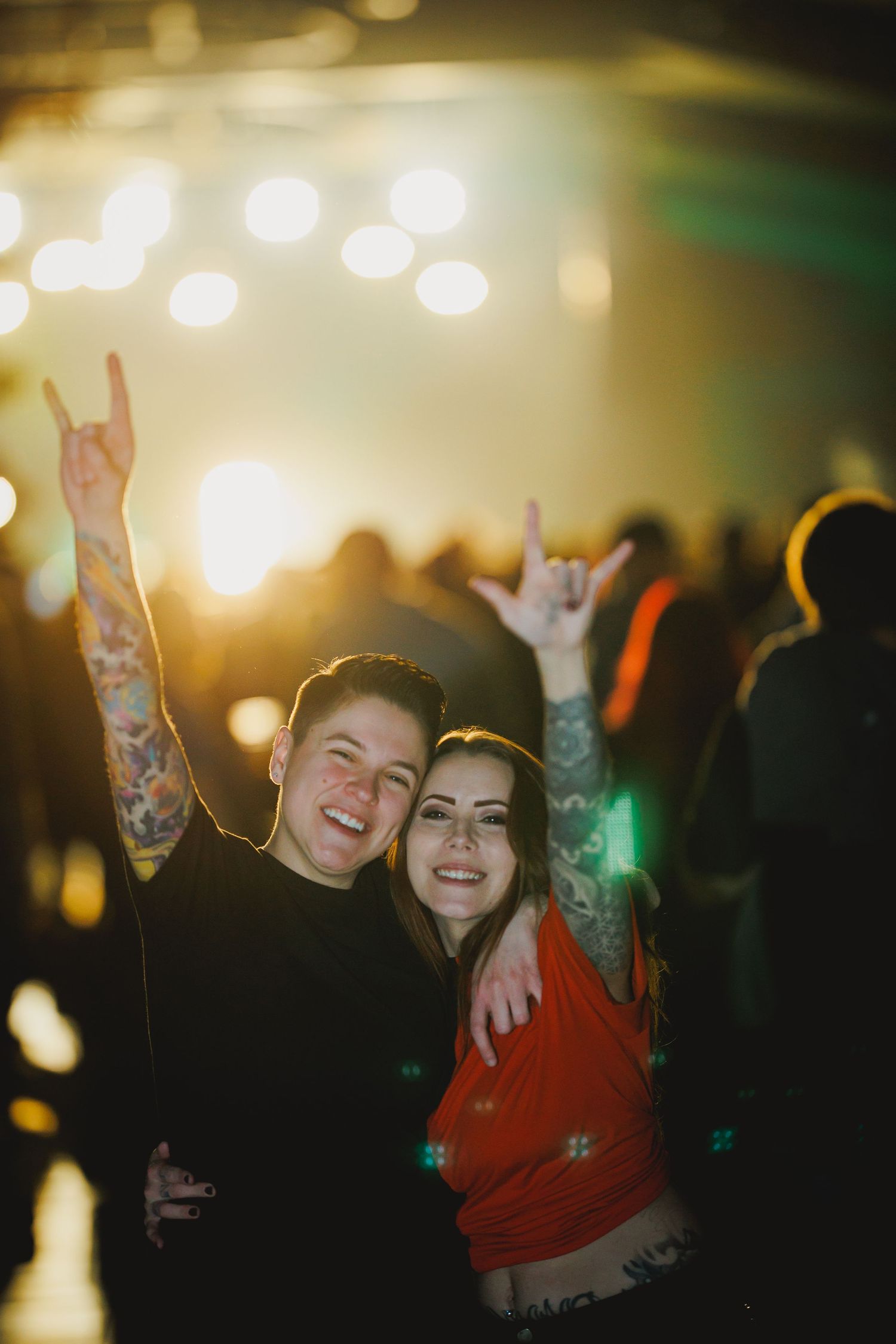 Energetic party scene with festive bokeh lighting and raised hands.