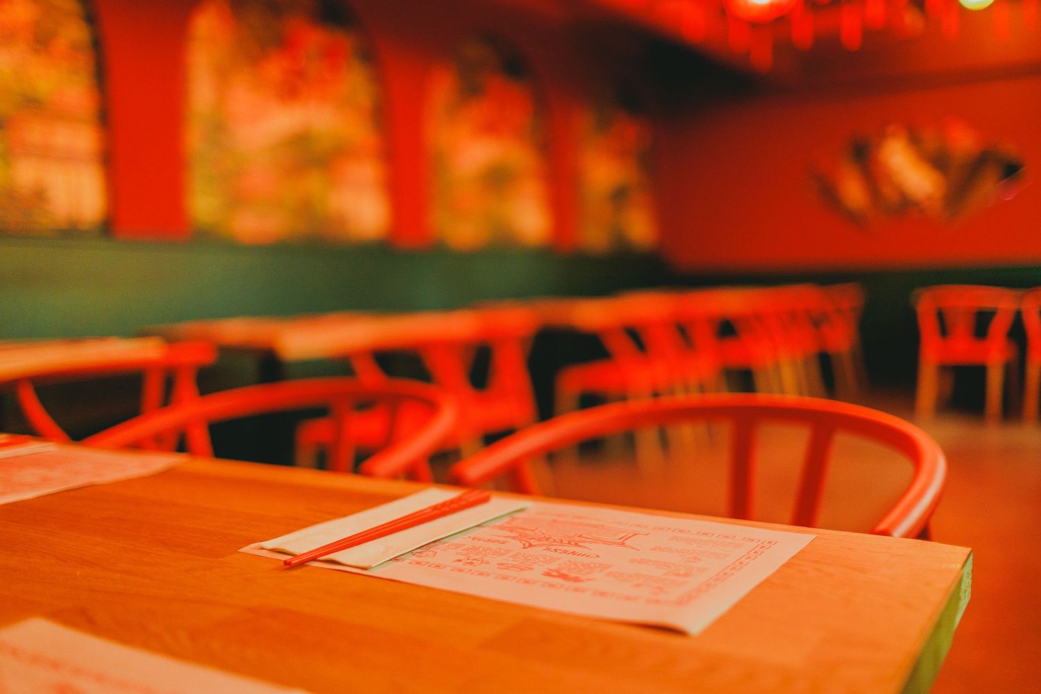 Red-lit tables and chairs arranged in rows at an event venue.