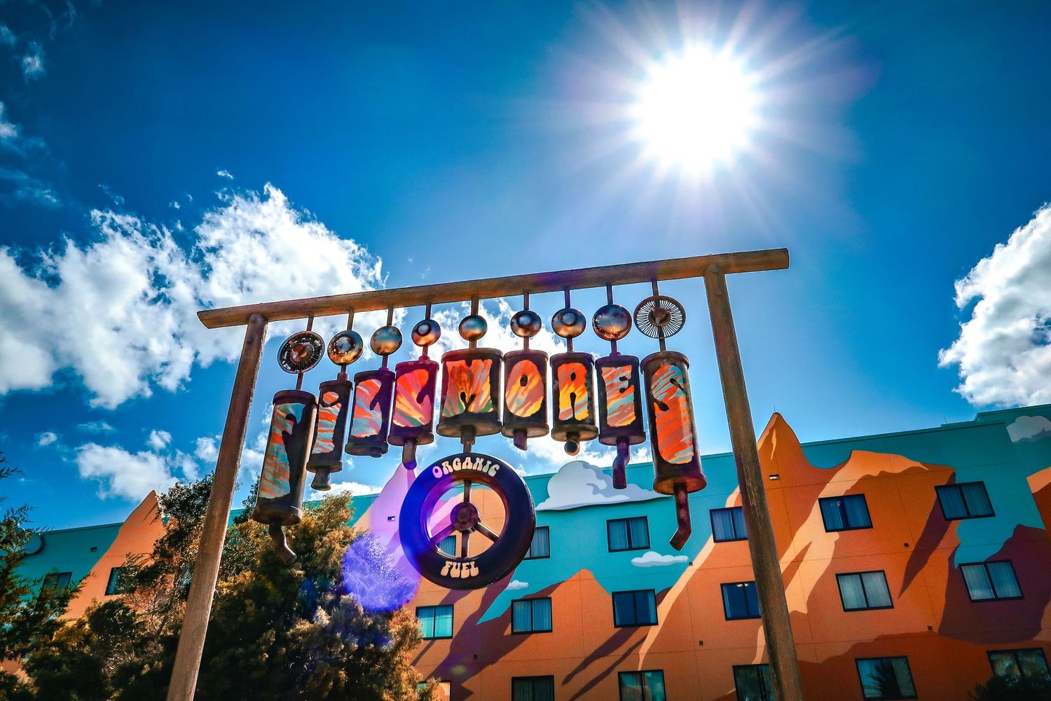 Colorful Imagines sign at Disney World's All-Star Movies Resort under a vivid blue sky.