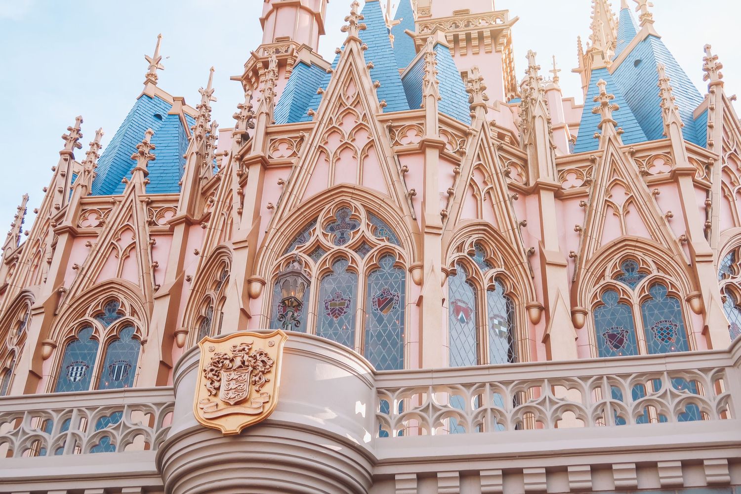 Close-up of Cinderella Castle's ornate Gothic architecture with blue spires at Disney World.