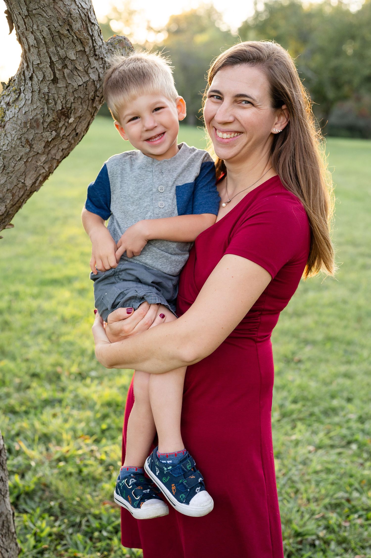 Outdoor portrait of two people by tree with golden sunset lighting.