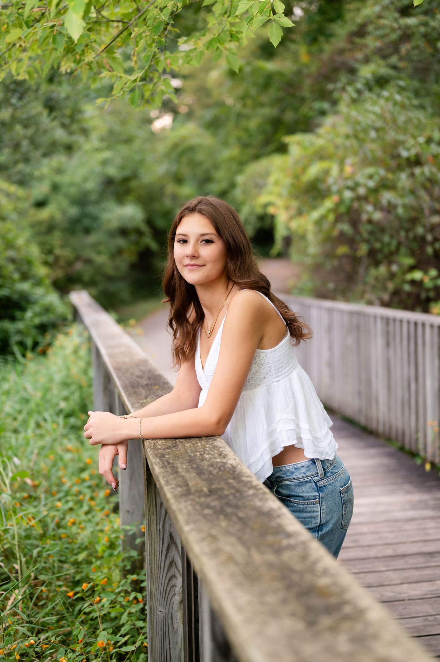 Summer portrait on a wooden boardwalk surrounded by lush green foliage.