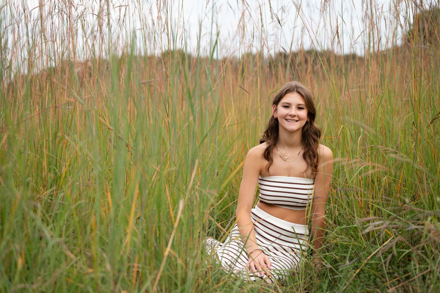 Summer portrait among tall grass wearing a striped outfit.