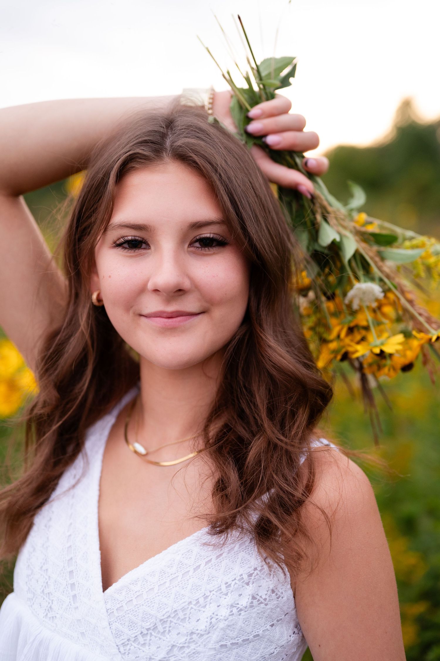 Summer portrait with yellow flowers and a white lace top in golden light.